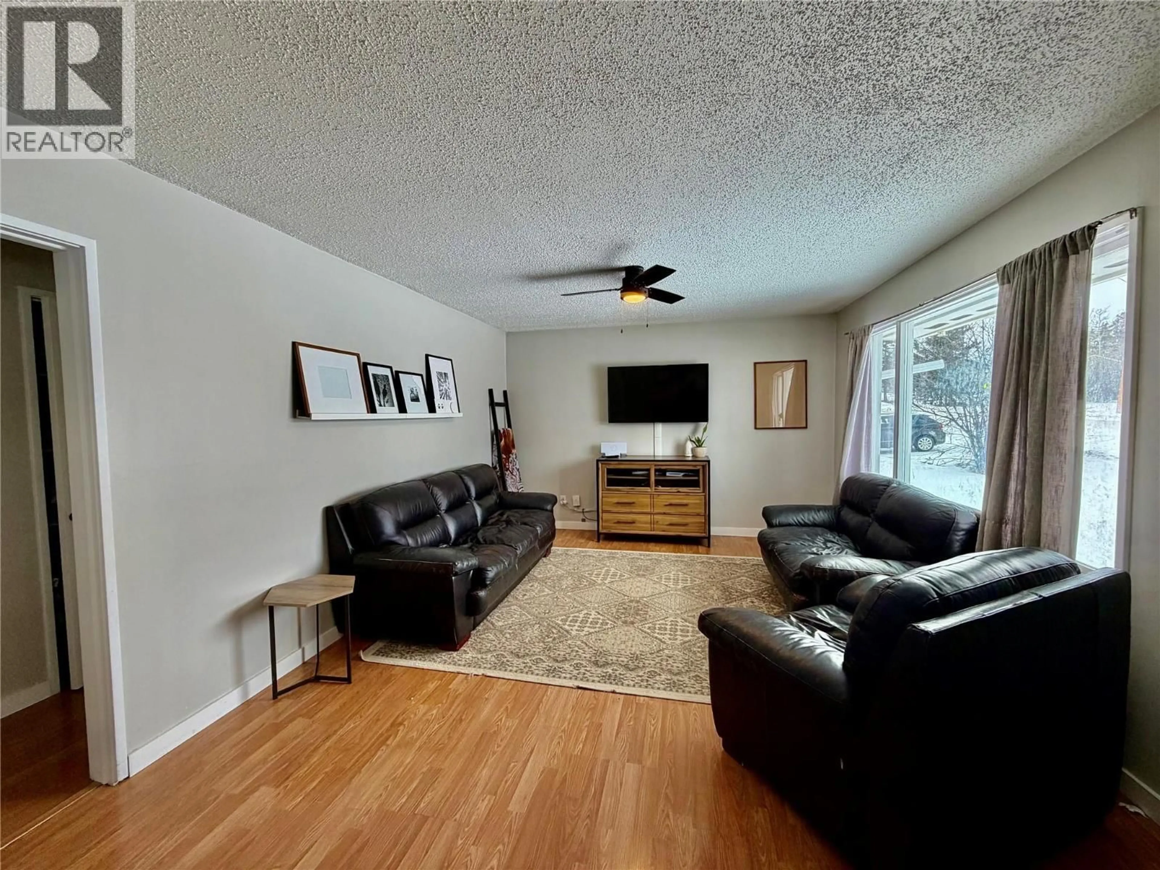 Living room with furniture, wood/laminate floor for 313 98 AVENUE, Dawson Creek British Columbia V1G1R8