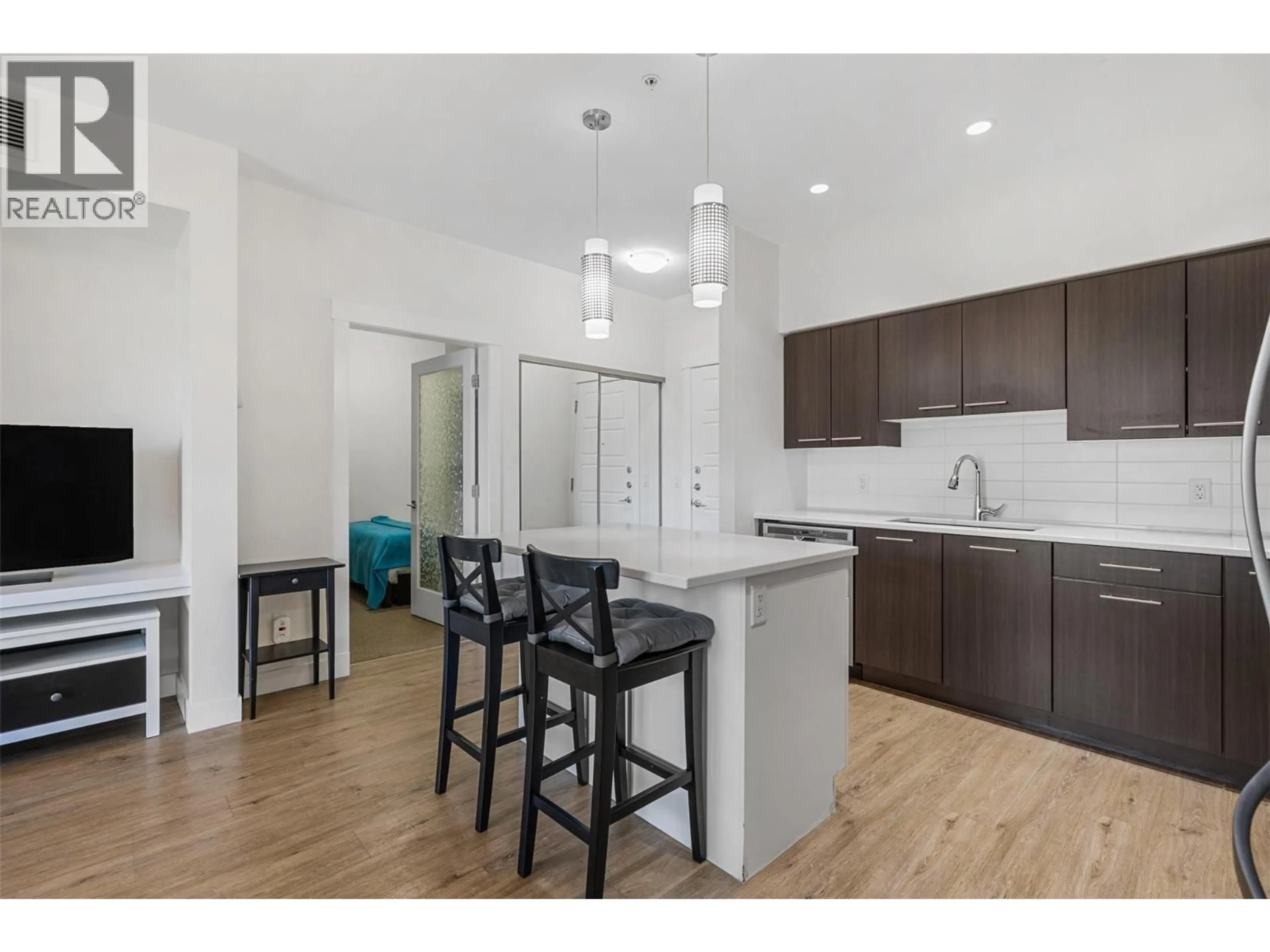 Open concept kitchen, wood/laminate floor for 104 - 985 ACADEMY WAY, Kelowna British Columbia V1V3C8