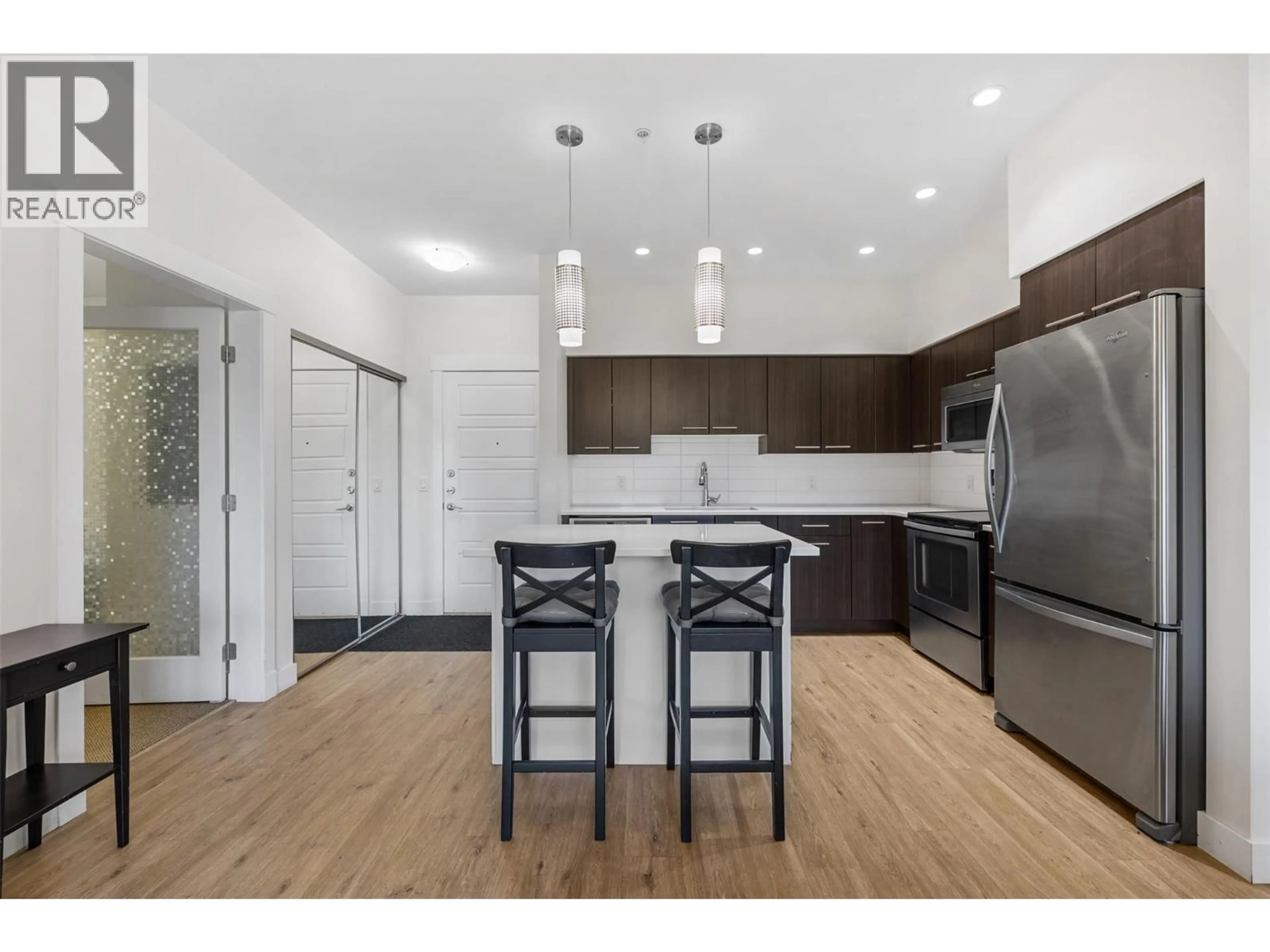 Open concept kitchen, wood/laminate floor for 104 - 985 ACADEMY WAY, Kelowna British Columbia V1V3C8