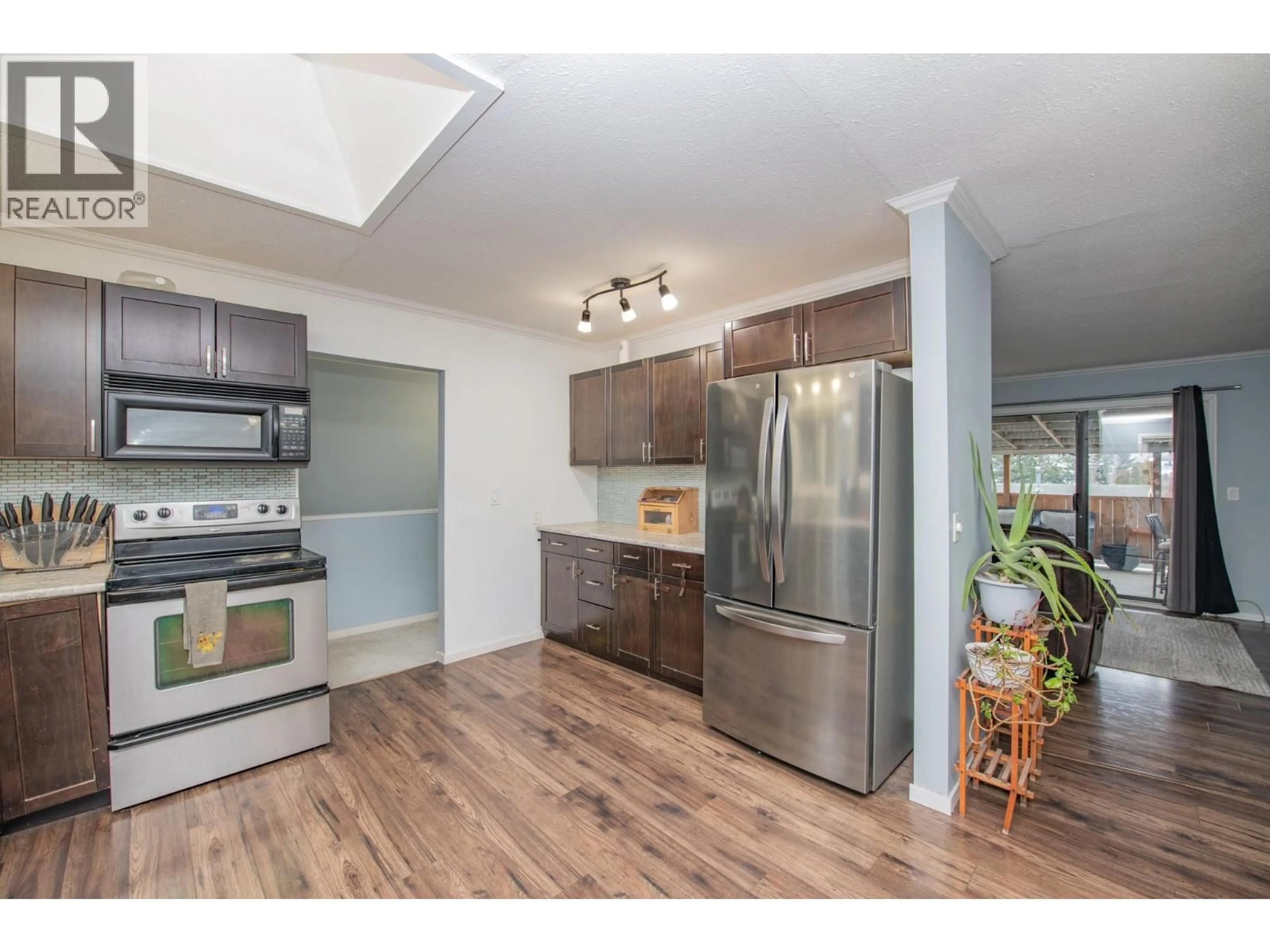 Open concept kitchen, wood/laminate floor for 2104 20 AVENUE, Vernon British Columbia V1T7J6