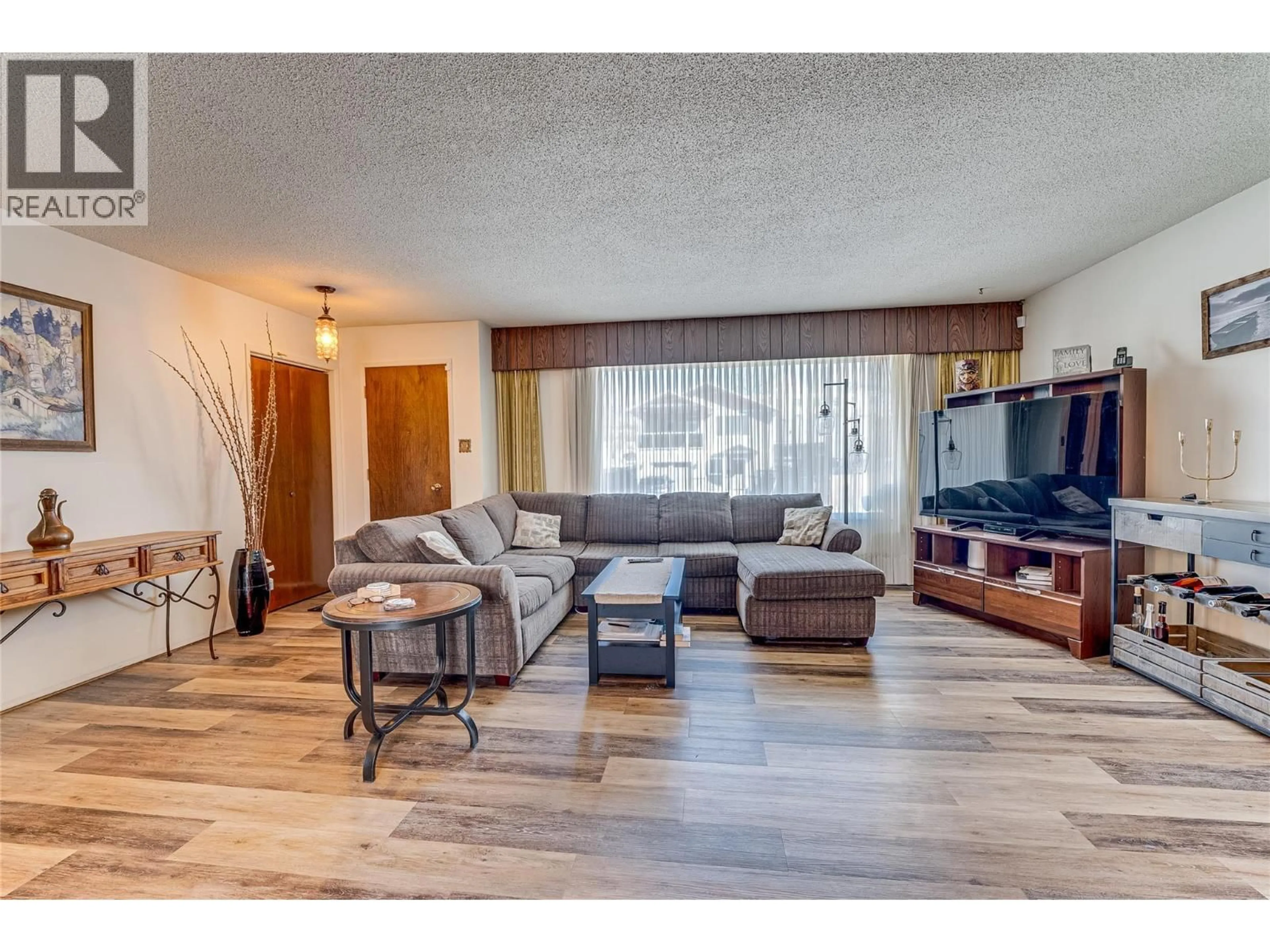 Living room with furniture, wood/laminate floor for 3508 24A AVENUE, Vernon British Columbia V1T1M3