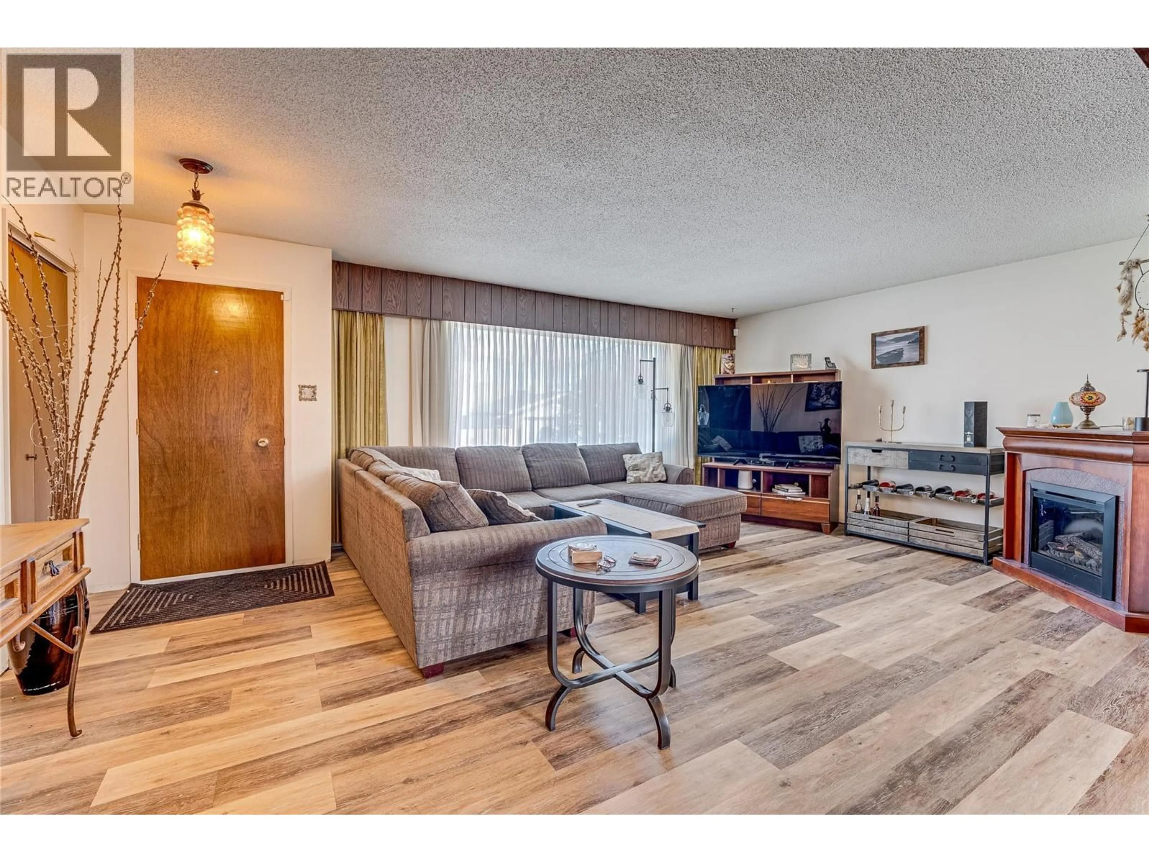 Living room with furniture, wood/laminate floor for 3508 24A AVENUE, Vernon British Columbia V1T1M3