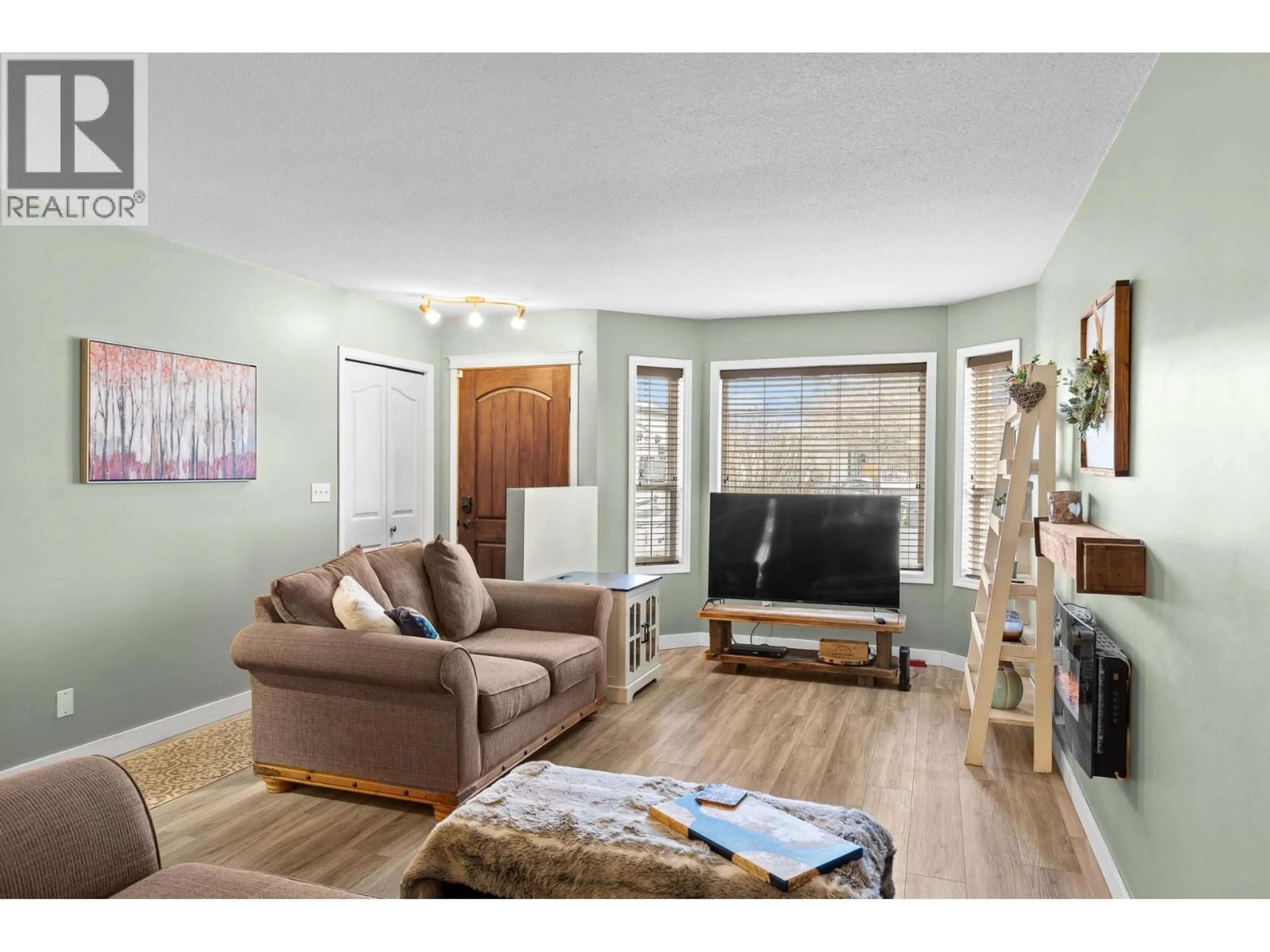 Living room with furniture, wood/laminate floor for 190 RITCHIE COURT, Kelowna British Columbia V1V2A8