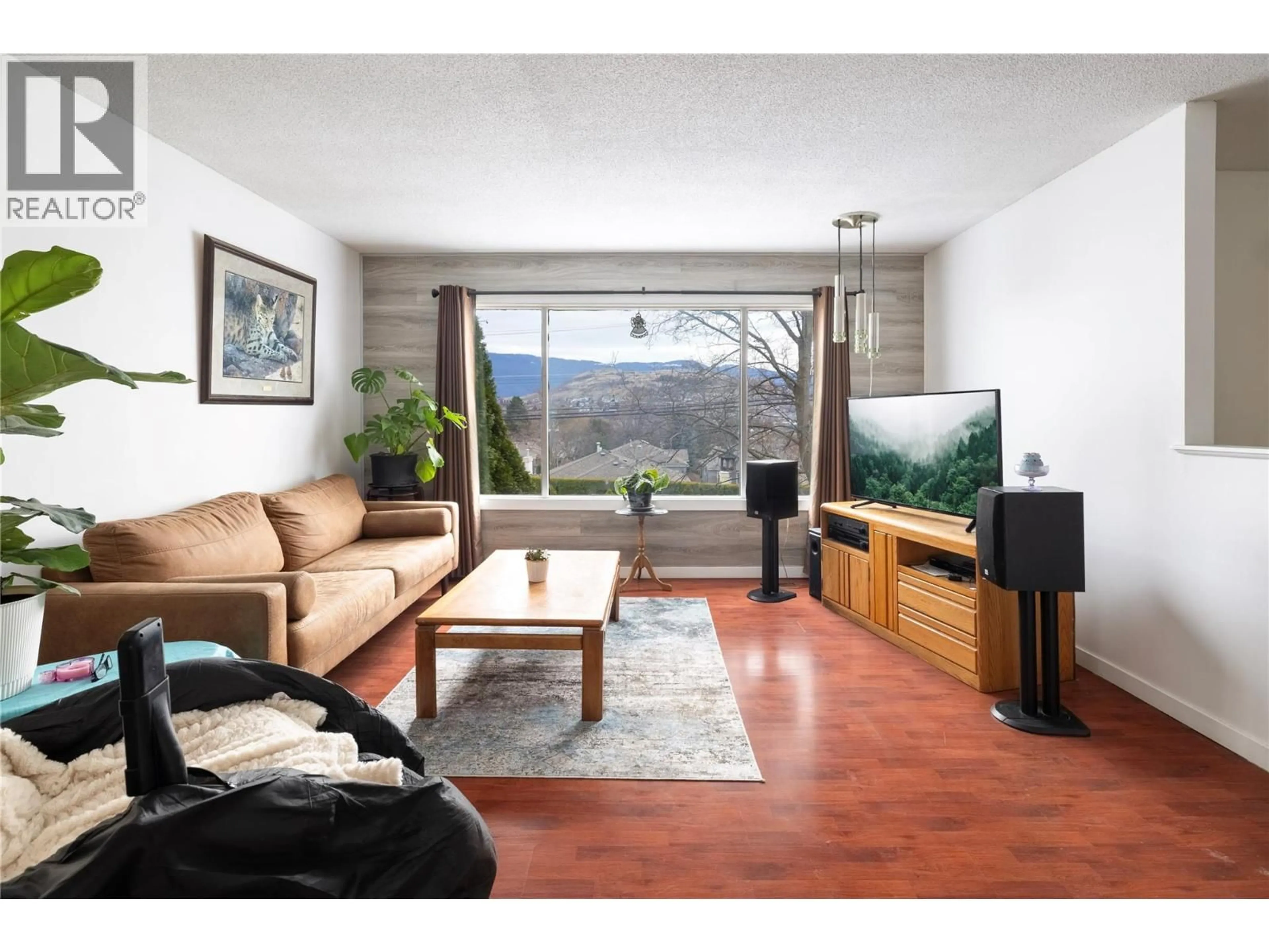 Living room with furniture, wood/laminate floor for 1203 25 AVENUE, Vernon British Columbia V1T7L5