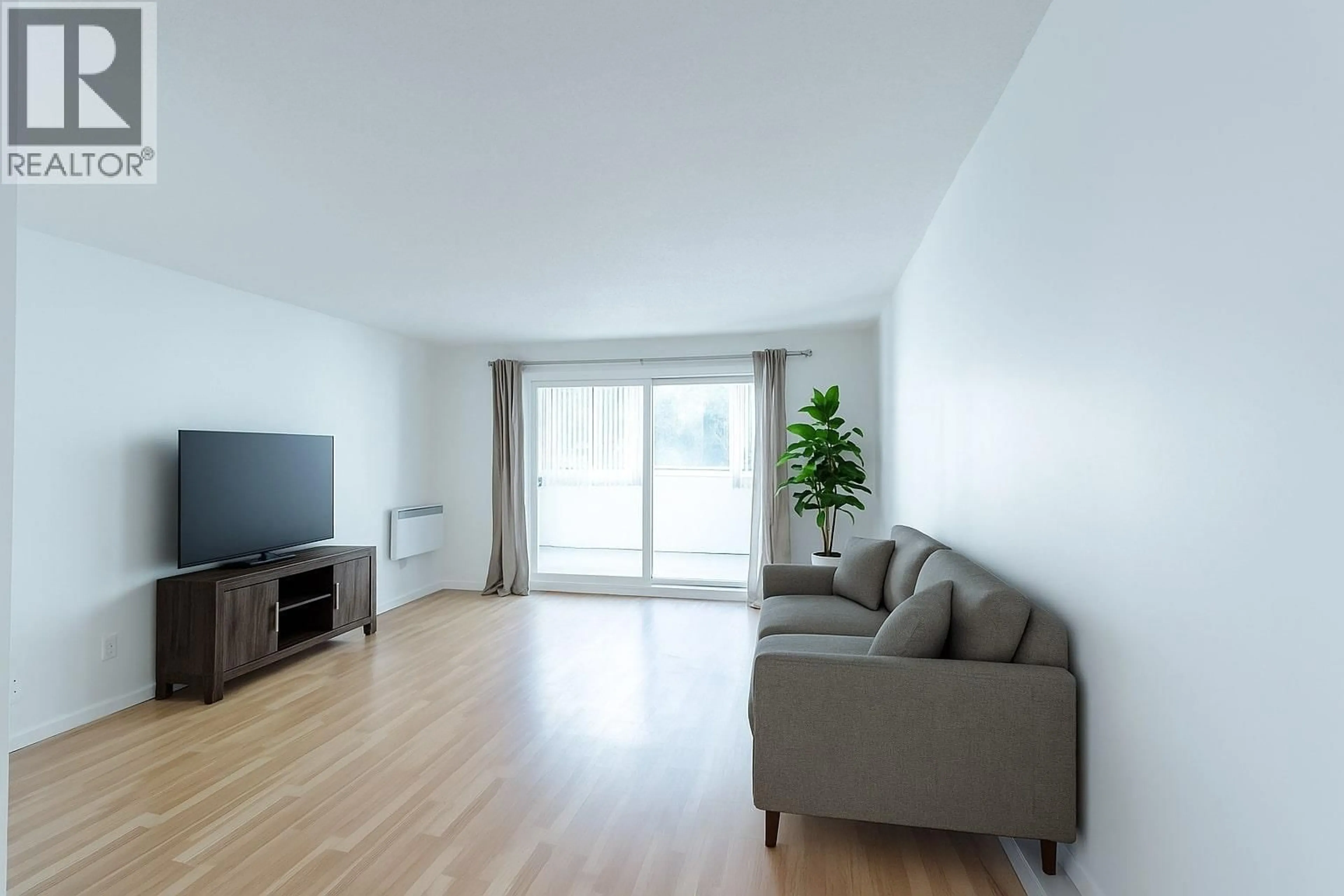 Living room with furniture, wood/laminate floor for 106 - 445 ALL STAR COURT, Kelowna British Columbia V1X5N7