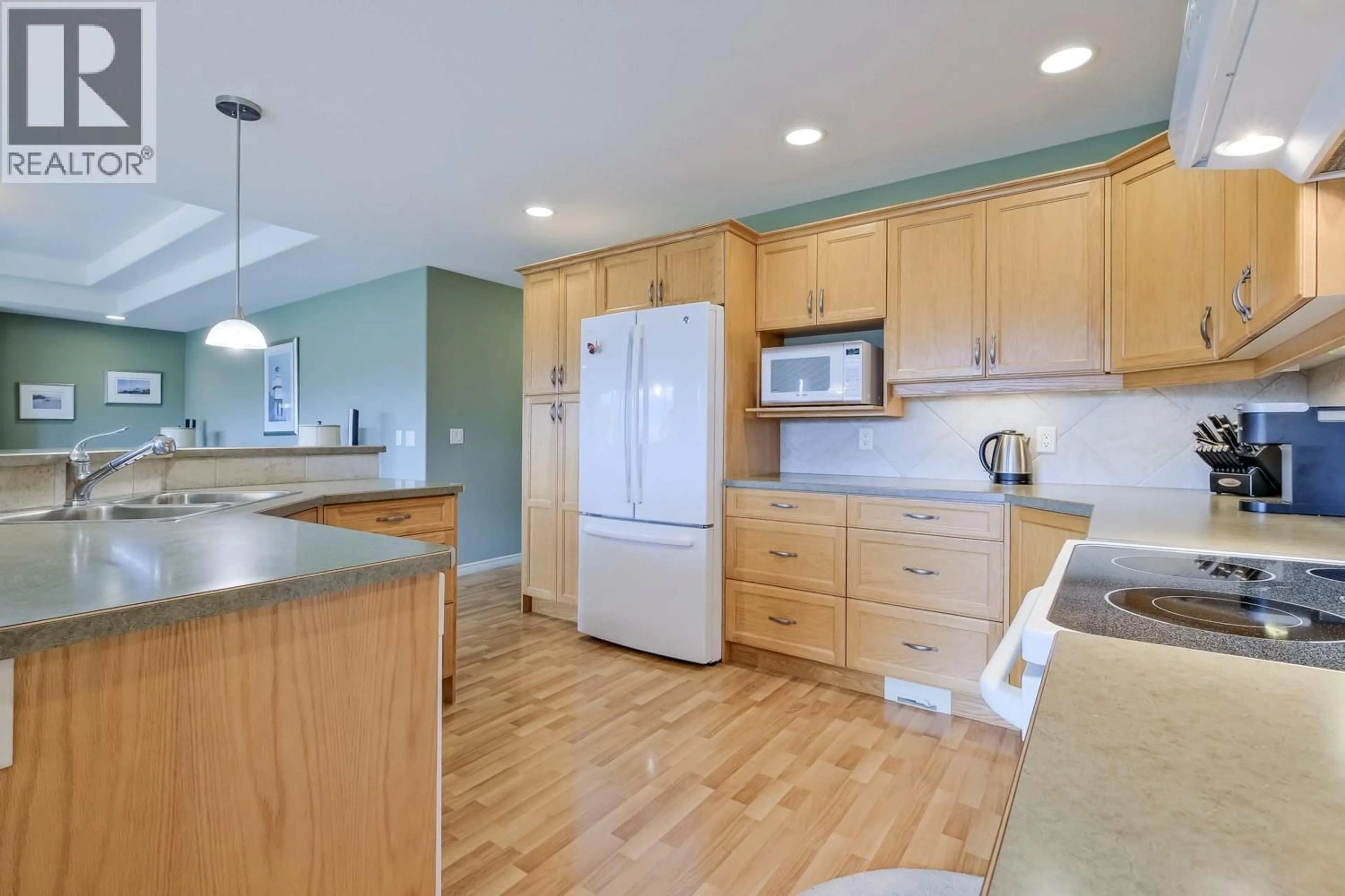 Open concept kitchen, wood/laminate floor for 111 - 2365 STILLINGFLEET ROAD, Kelowna British Columbia V1W4X5