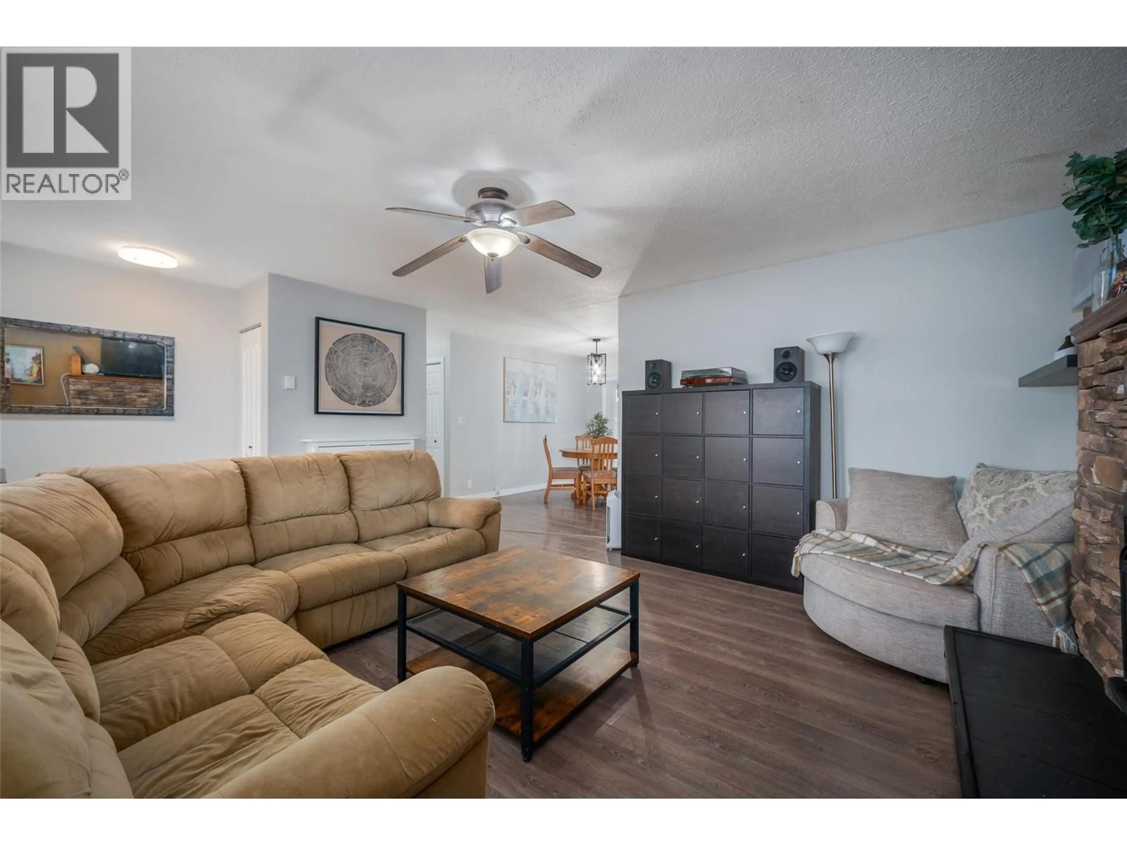 Living room with furniture, wood/laminate floor for 4840 SCOTTY CREEK ROAD, Kelowna British Columbia V1X6J8