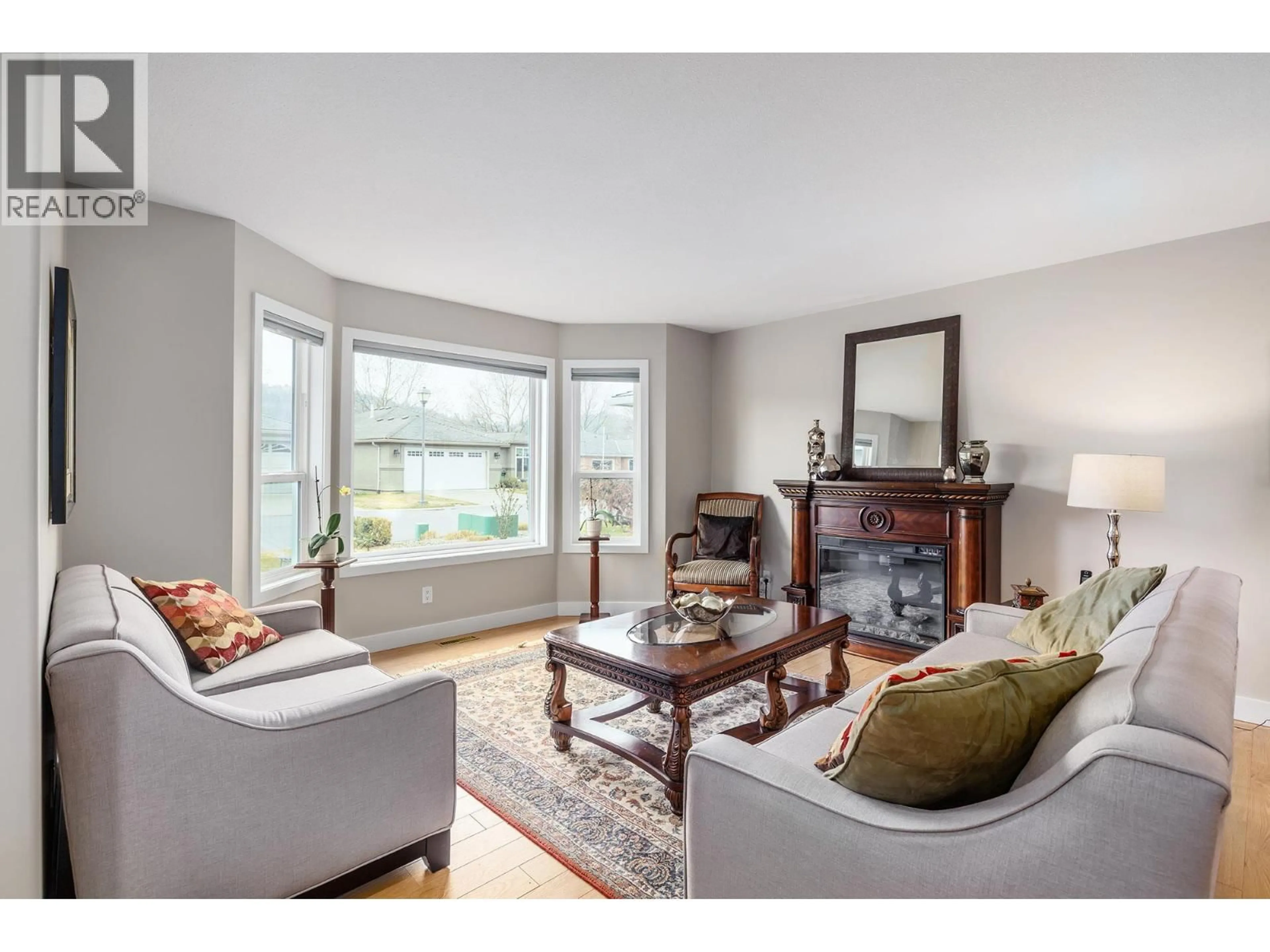 Living room with furniture, wood/laminate floor for 2 - 615 GLENMEADOWS ROAD, Kelowna British Columbia V1V1N9