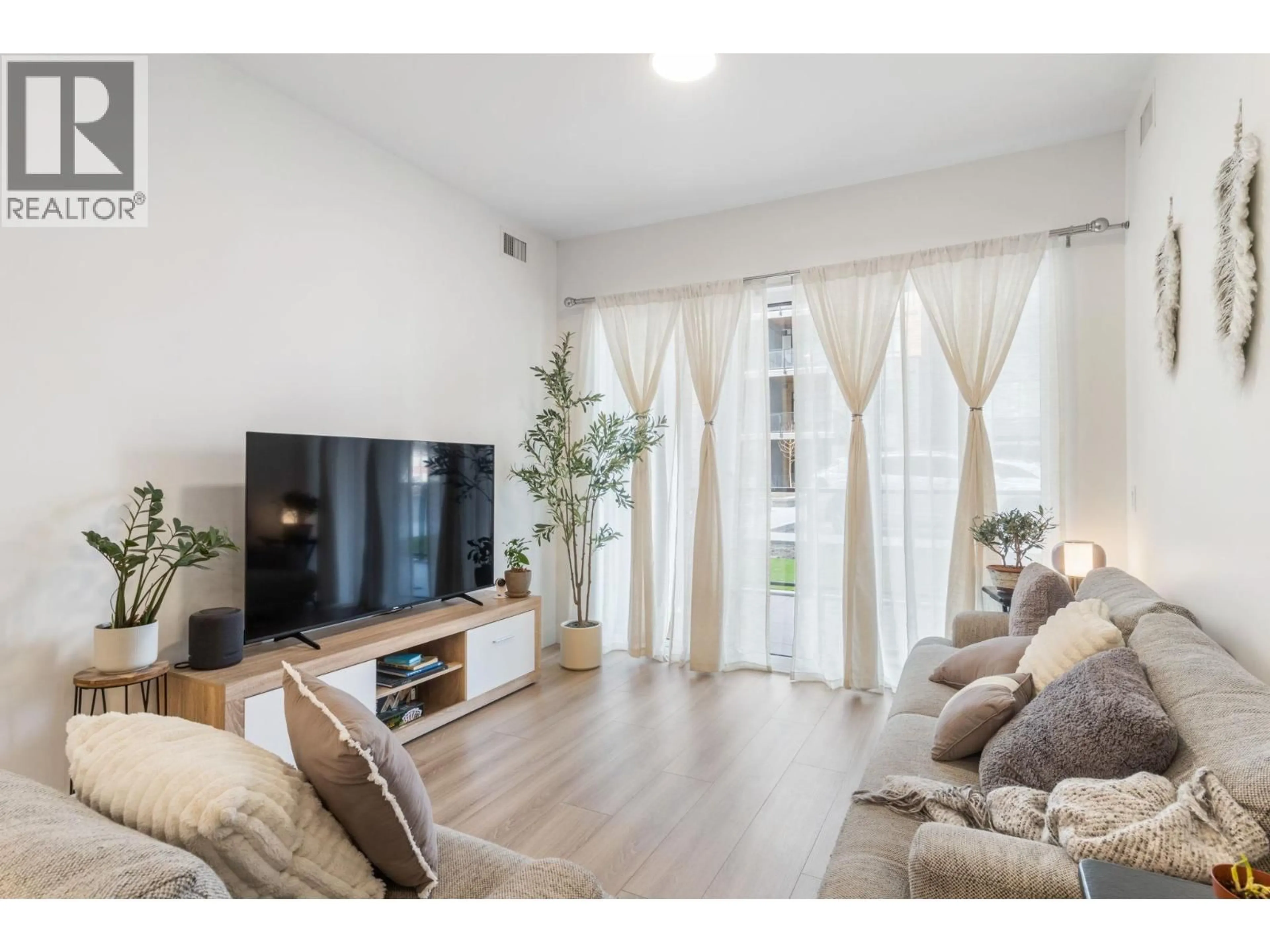 Living room with furniture, wood/laminate floor for 101 - 2780 OLALLA ROAD, West Kelowna British Columbia V1Z2A9