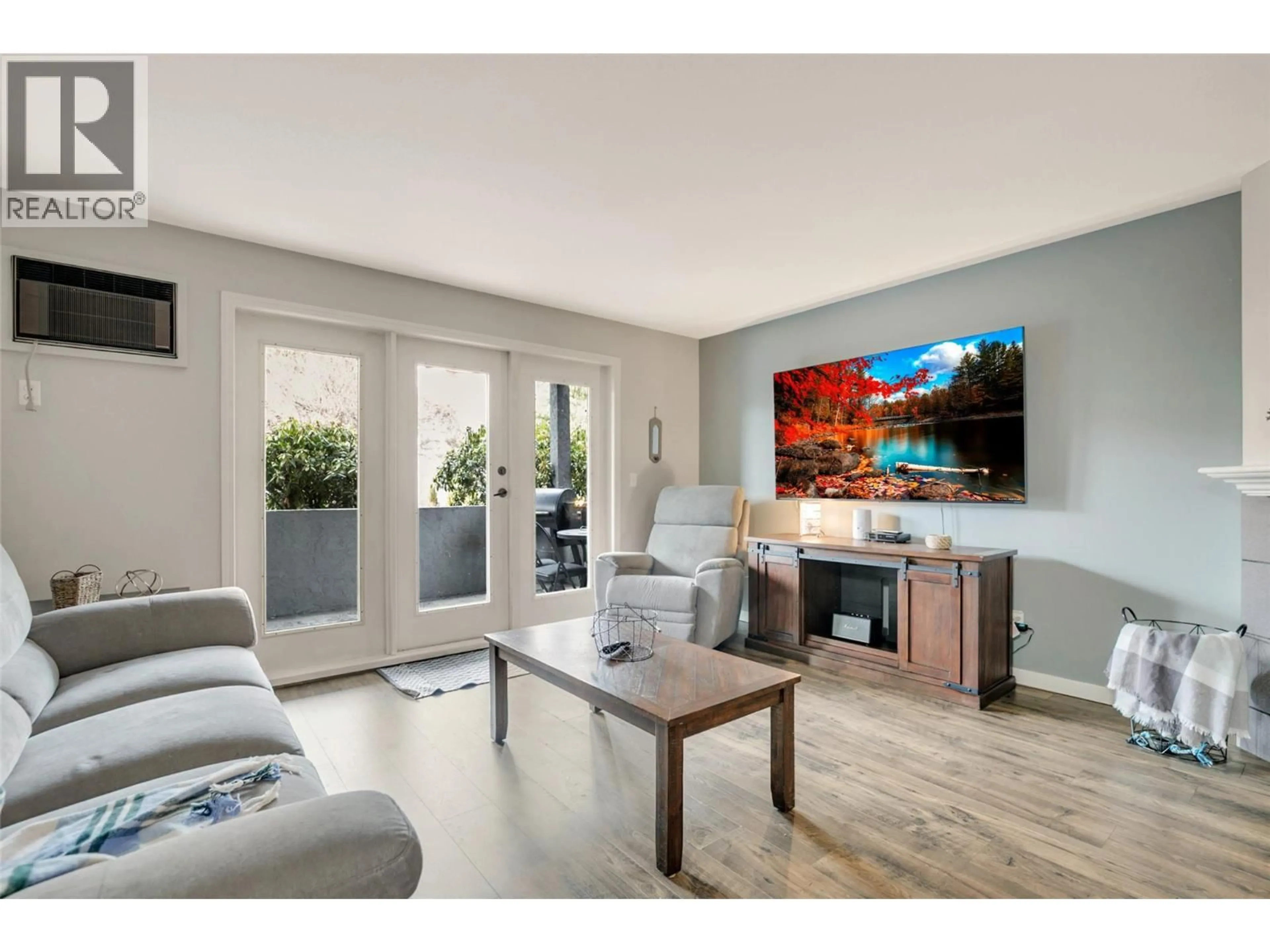 Living room with furniture, wood/laminate floor for 115 - 3175 DE MONTREUIL COURT COURT, Kelowna British Columbia V1W3W2