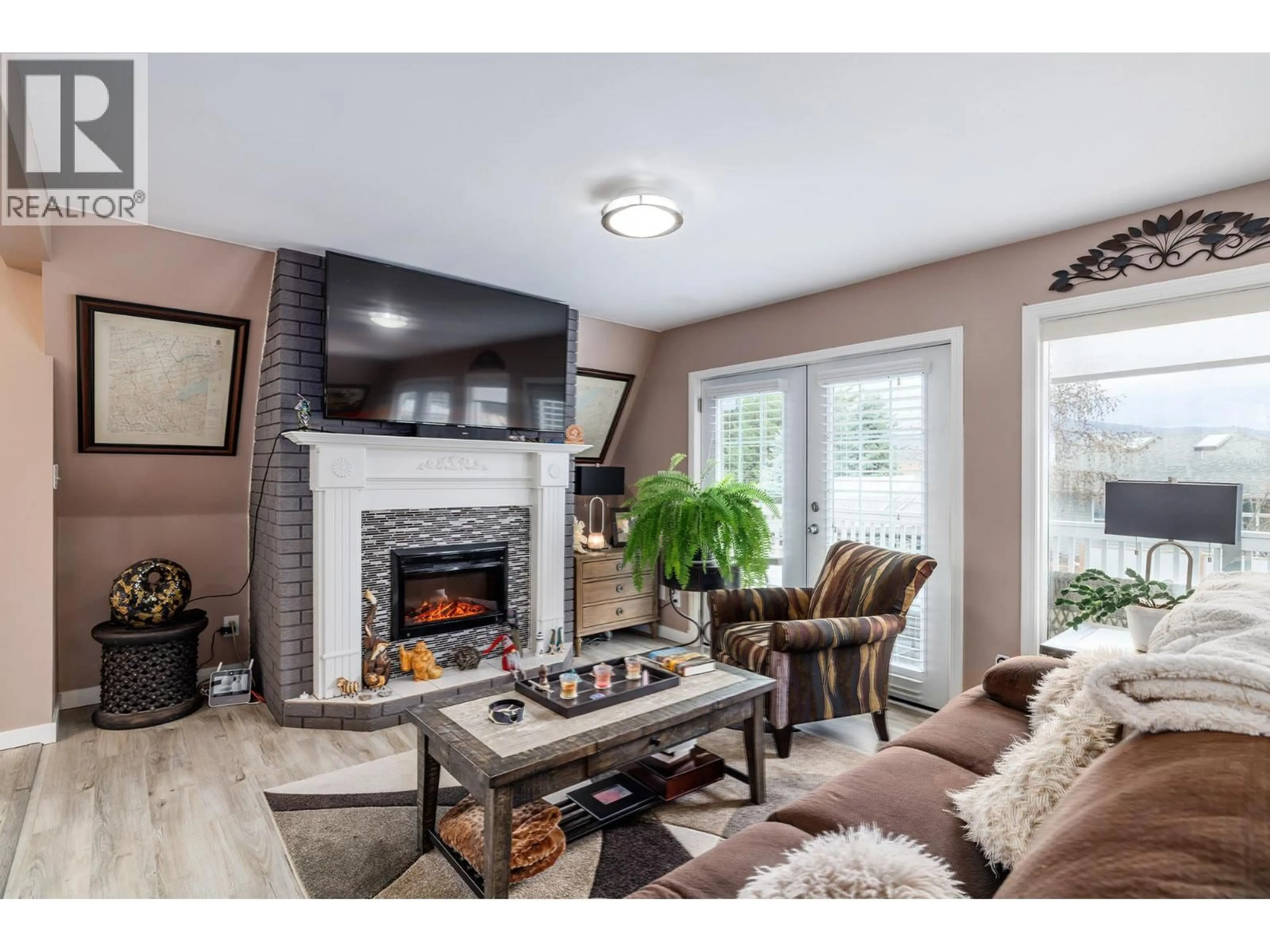 Living room with furniture, wood/laminate floor for 682 COUGAR STREET, Vernon British Columbia V1H2A1