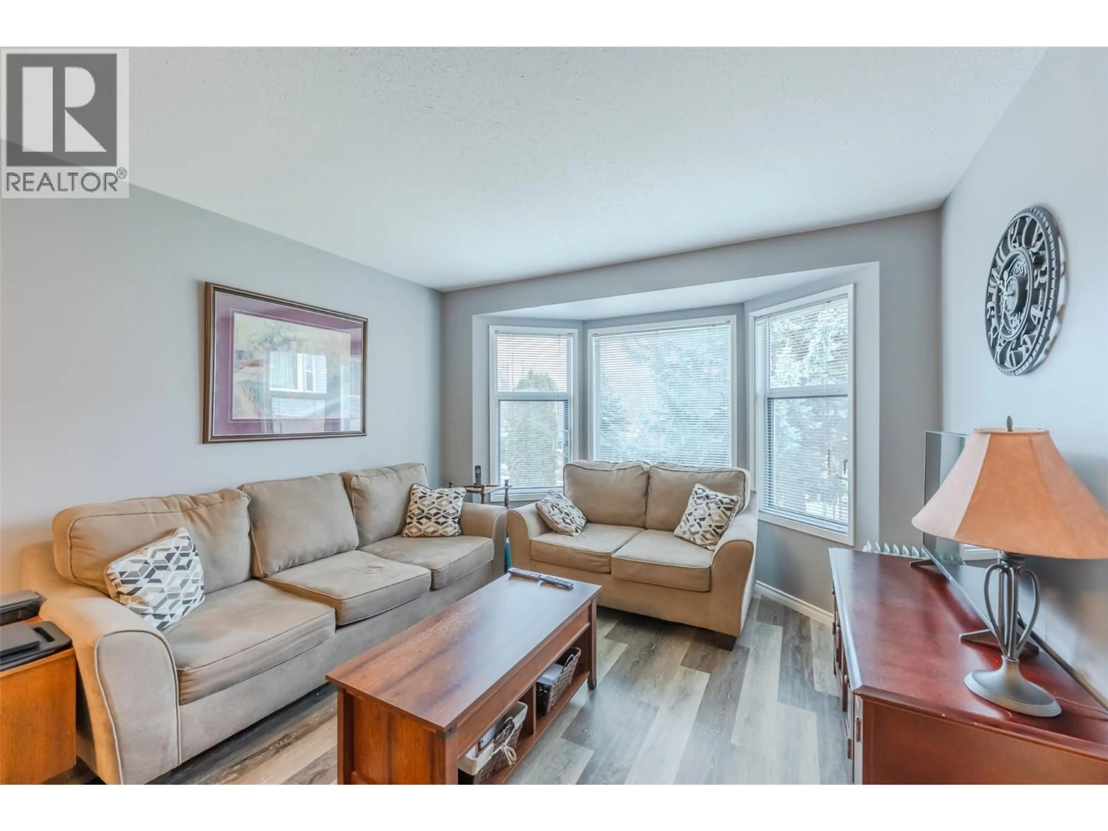 Living room with furniture, wood/laminate floor for 3 - 7720 PRAIRIE VALLEY ROAD, Summerland British Columbia V0H1Z4