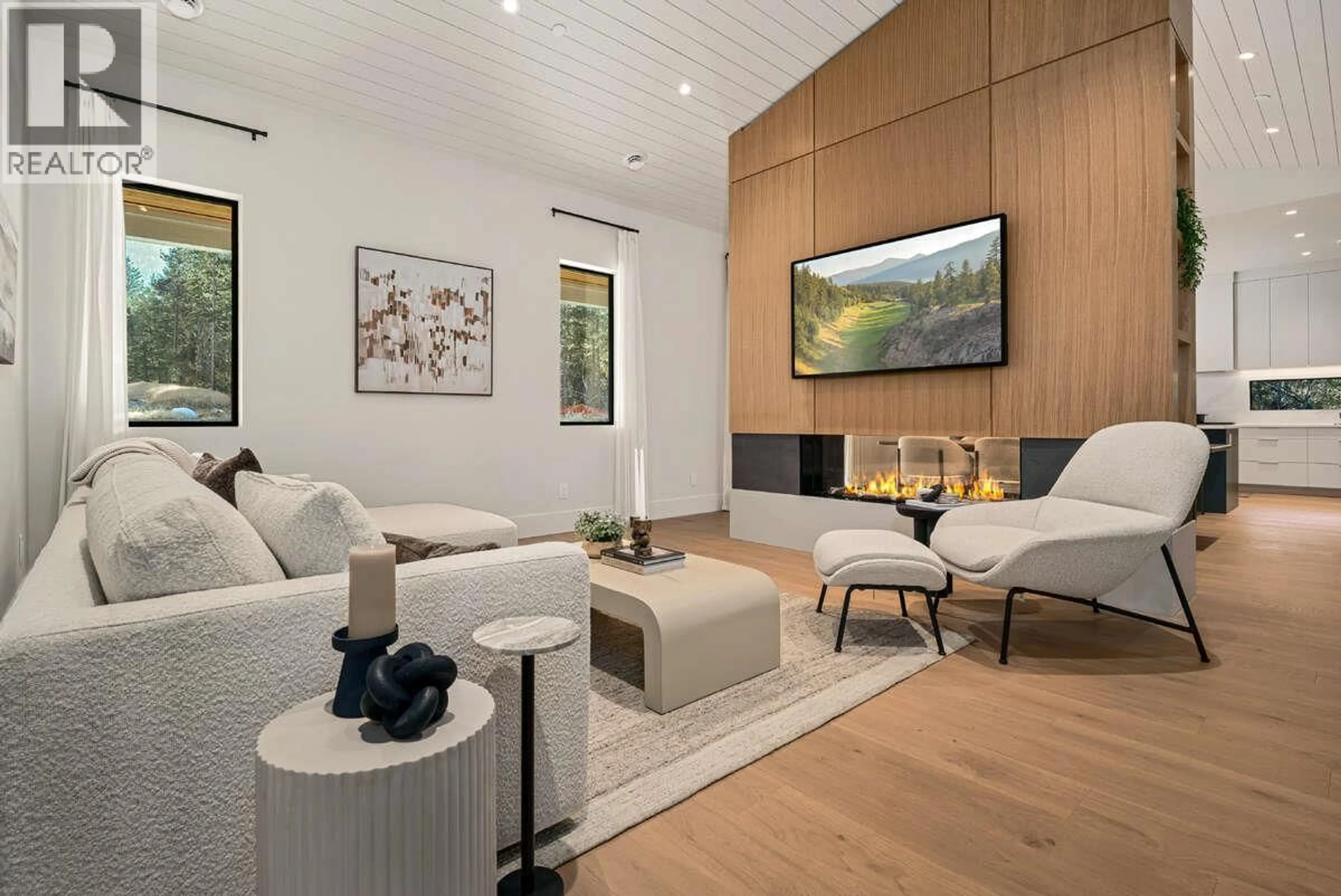 Living room with furniture, wood/laminate floor for 1 - 799 PREDATOR RIDGE DRIVE, Vernon British Columbia V1H1G4