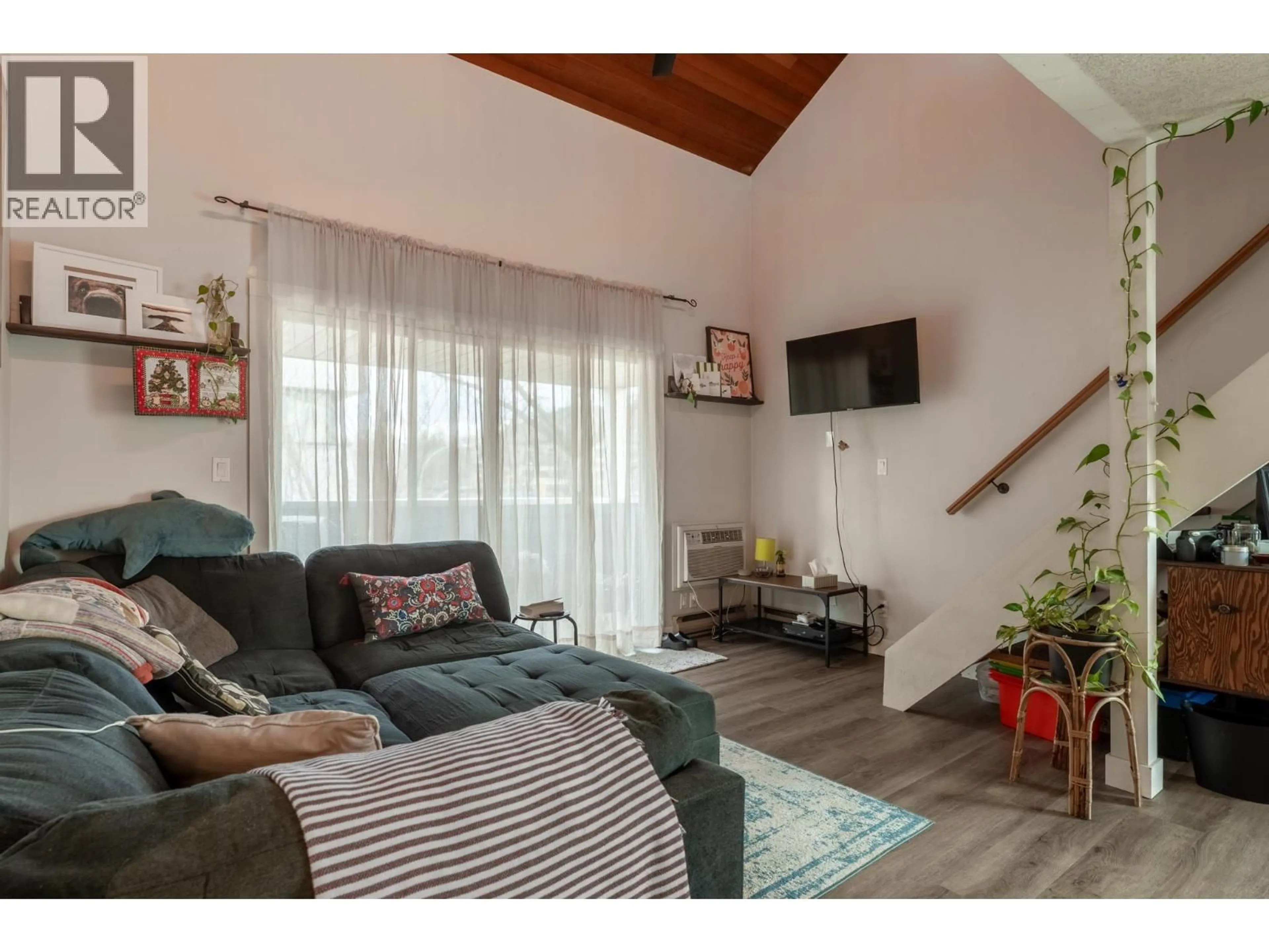 Living room with furniture, wood/laminate floor for 305 - 1685 UFTON COURT, Kelowna British Columbia V1Y8G7