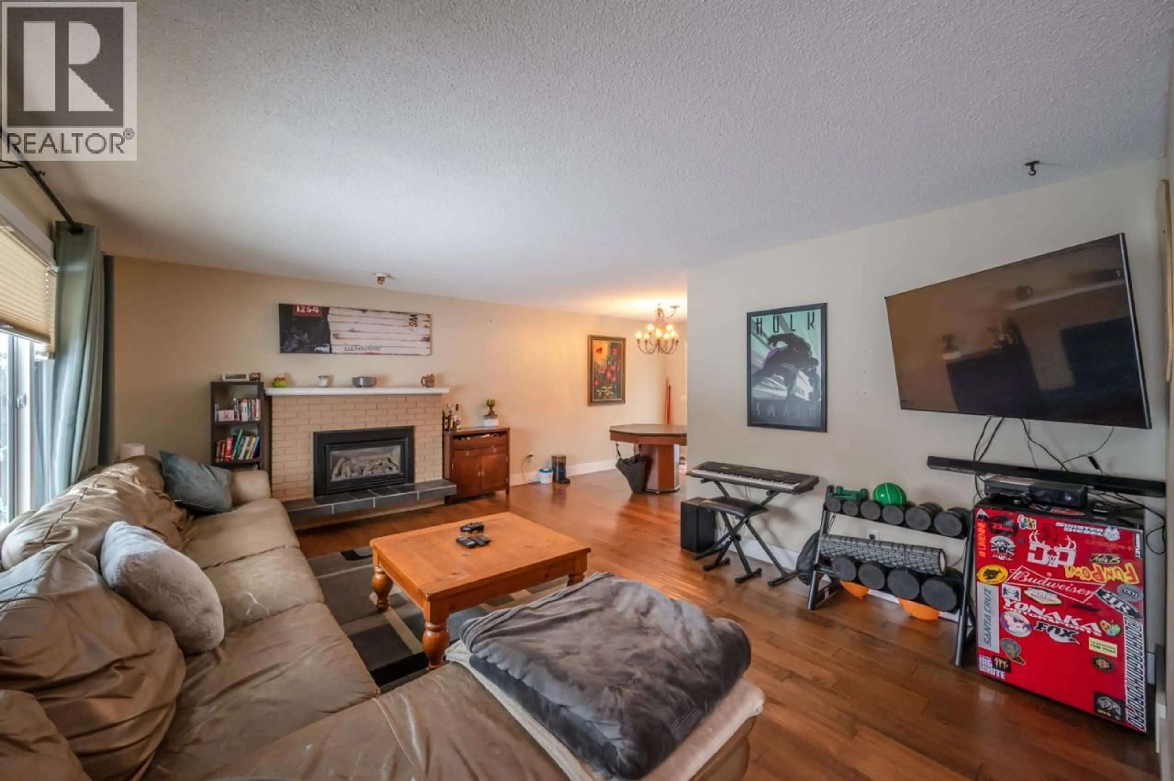 Living room with furniture, wood/laminate floor for 668 TOZER AVENUE, Kelowna British Columbia V1W2A5