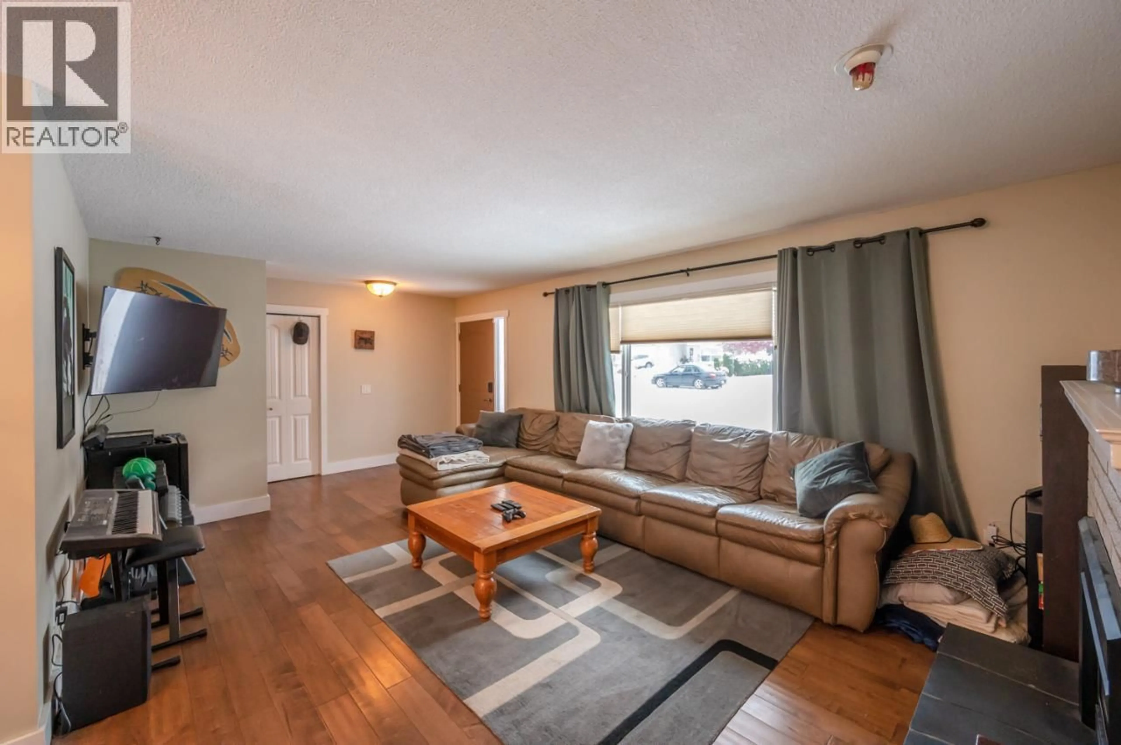 Living room with furniture, wood/laminate floor for 668 TOZER AVENUE, Kelowna British Columbia V1W2A5