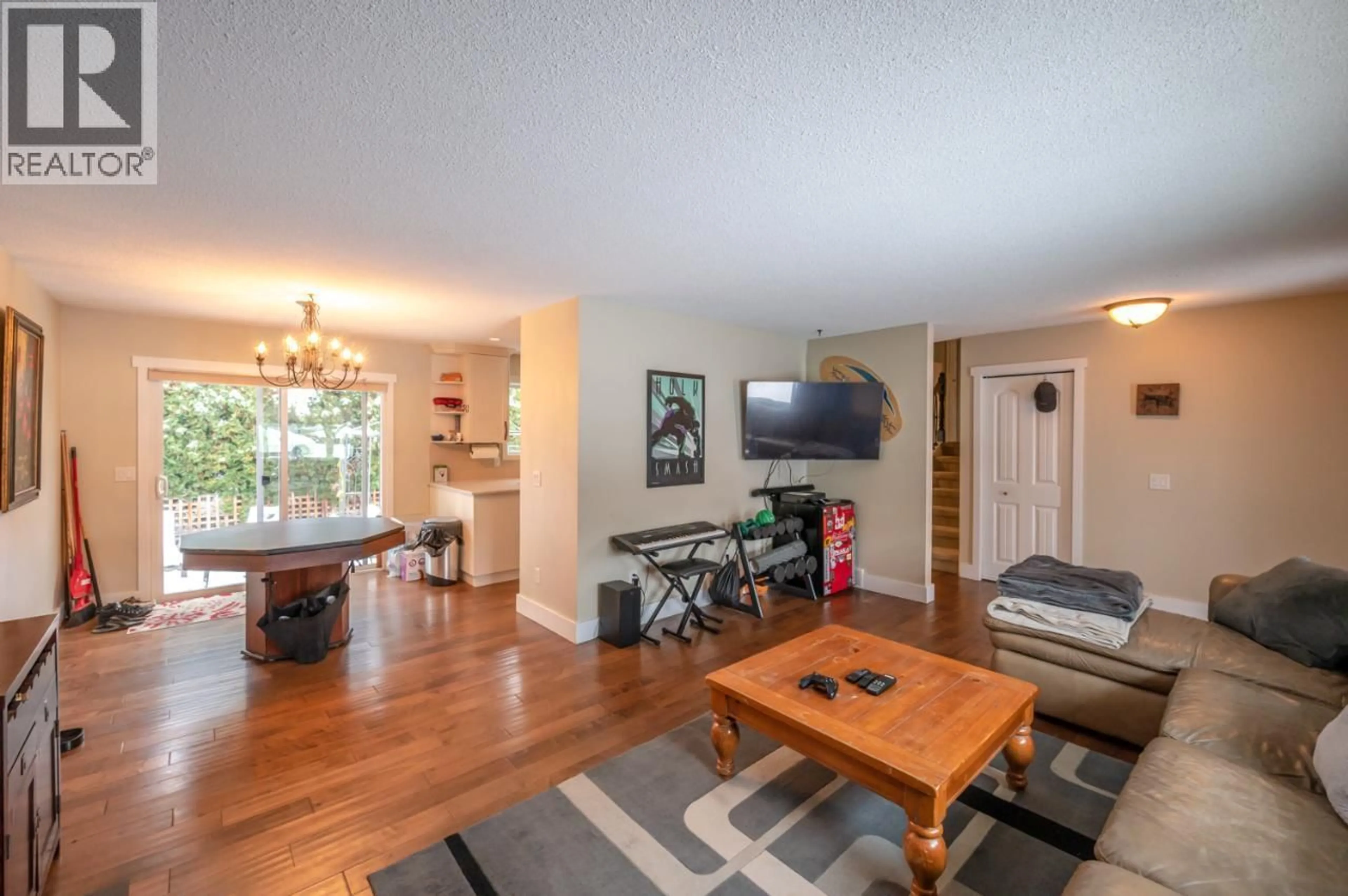 Living room with furniture, wood/laminate floor for 668 TOZER AVENUE, Kelowna British Columbia V1W2A5