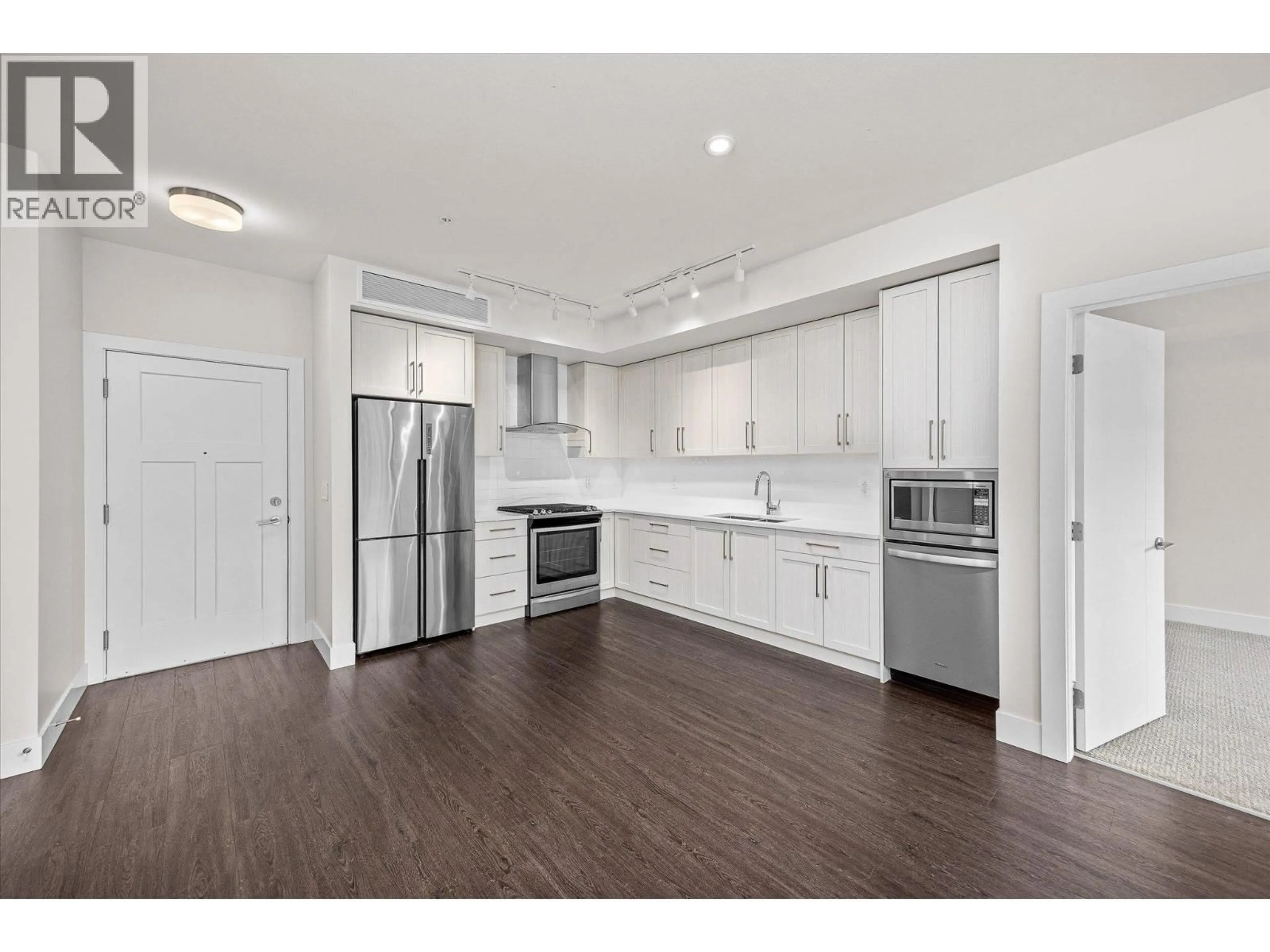 Open concept kitchen, wood/laminate floor for 105 - 4380 LAKESHORE ROAD, Kelowna British Columbia V1W5N3