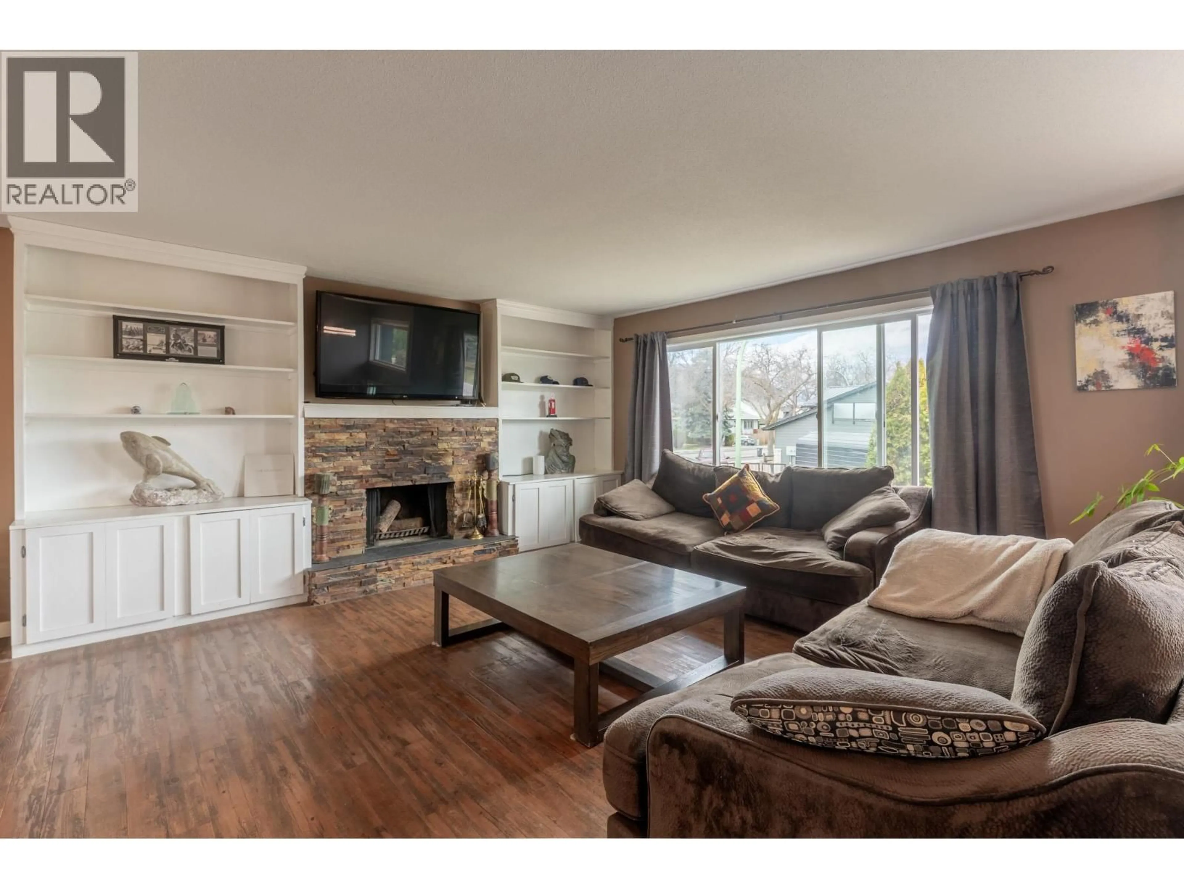 Living room with furniture, wood/laminate floor for 909 GRENFELL COURT, Kelowna British Columbia V1Y8C5