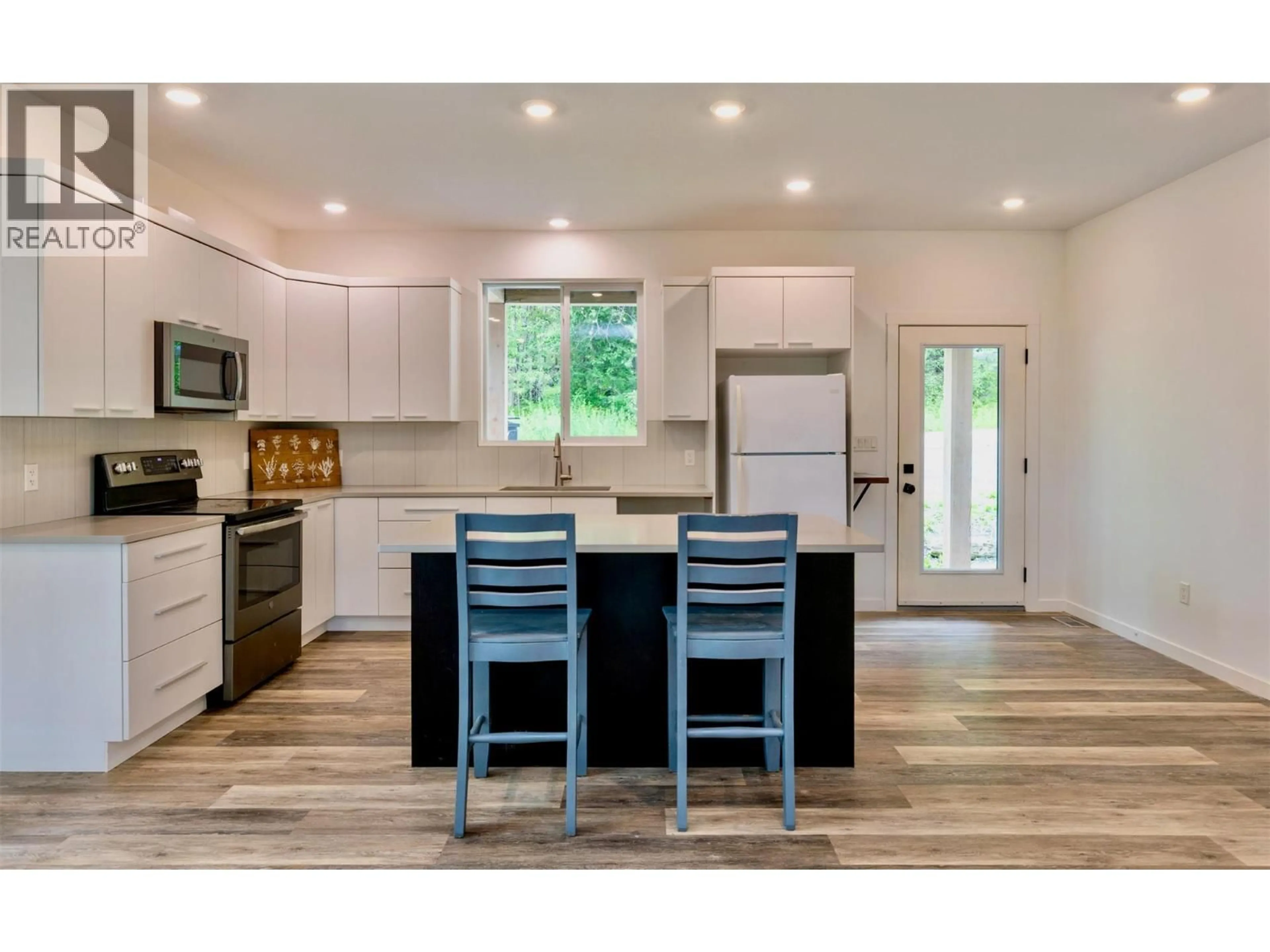 Open concept kitchen, wood/laminate floor for 7468 ESTATE DRIVE, Anglemont British Columbia V0E1M8