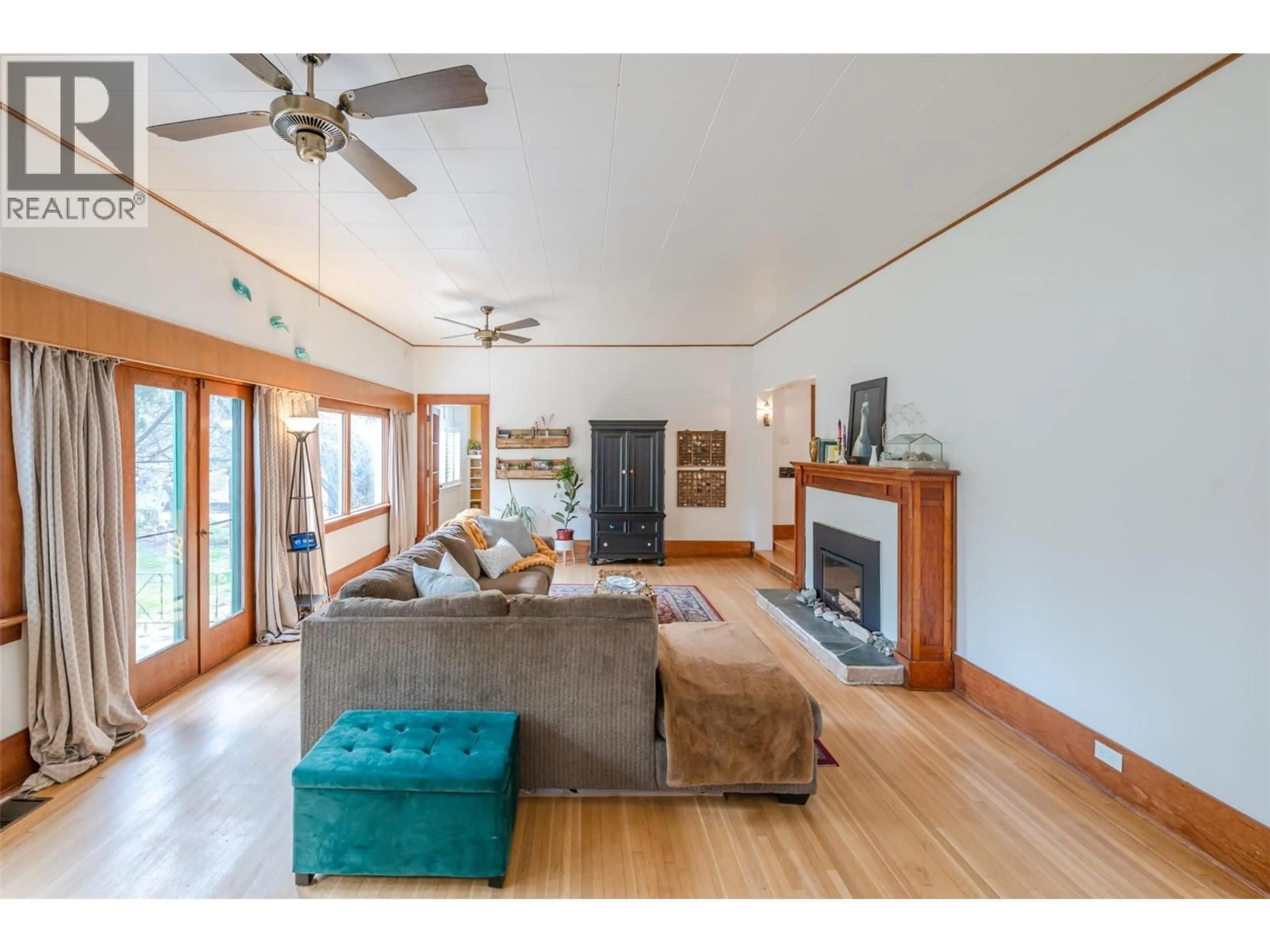 Living room with furniture, wood/laminate floor for 100 HUTH AVENUE, Penticton British Columbia V2A2Z9