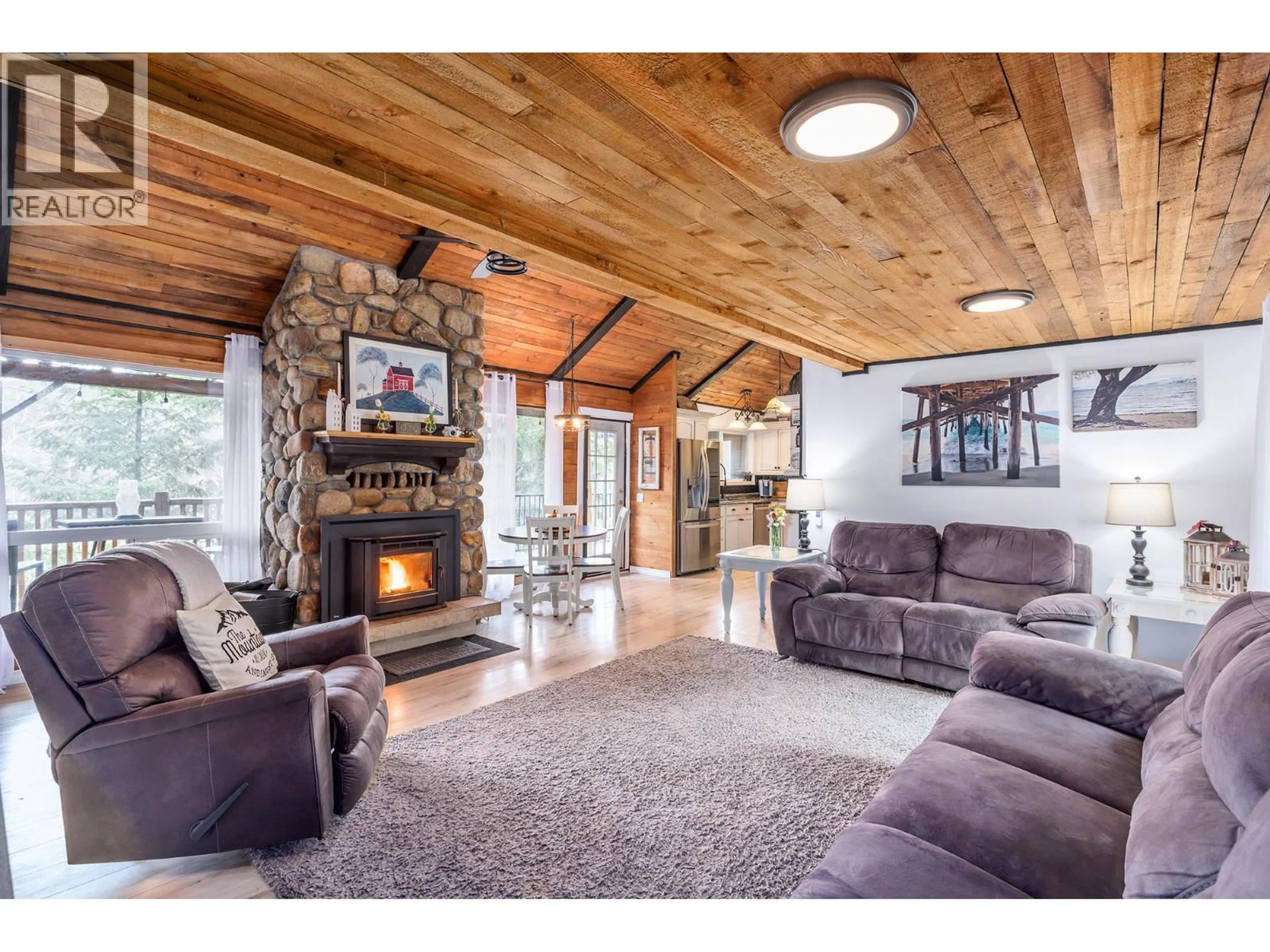 Living room with furniture, wood/laminate floor for 11251 THREE FORKS ROAD, Kelowna British Columbia V1P1J8