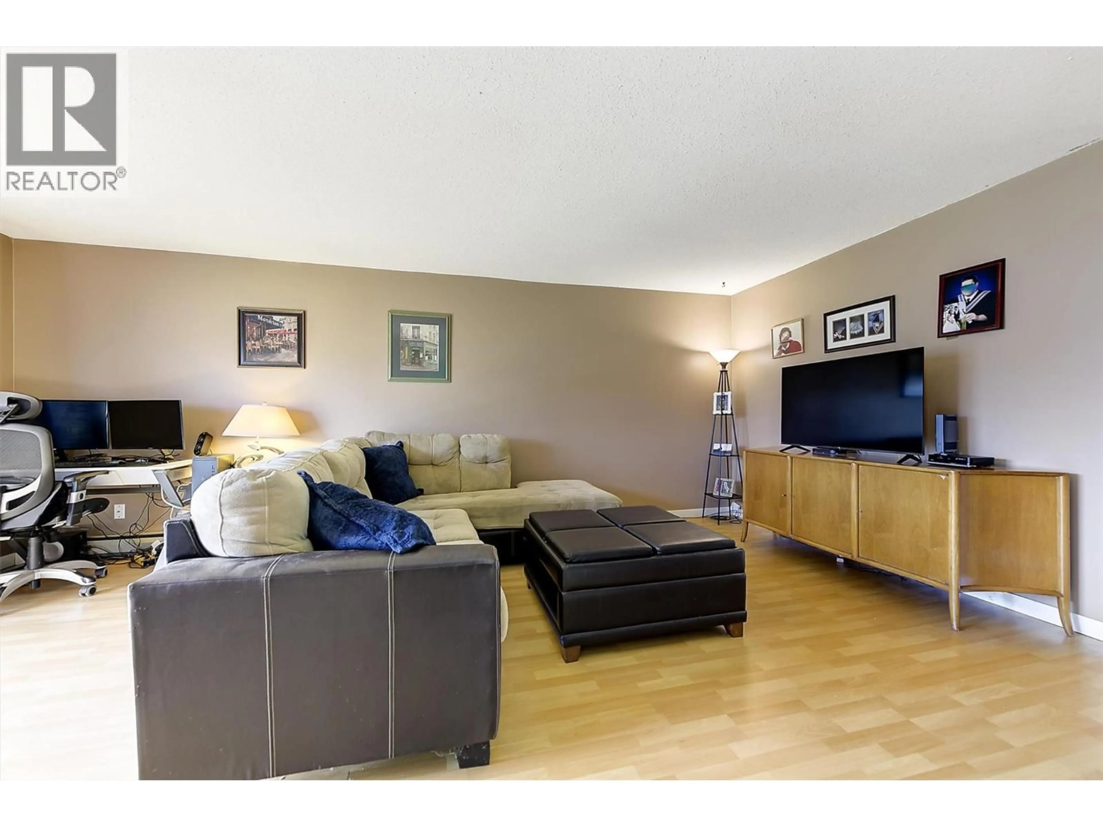 Living room with furniture, wood/laminate floor for 102 - 215 MILLS ROAD, Kelowna British Columbia V1X4G6
