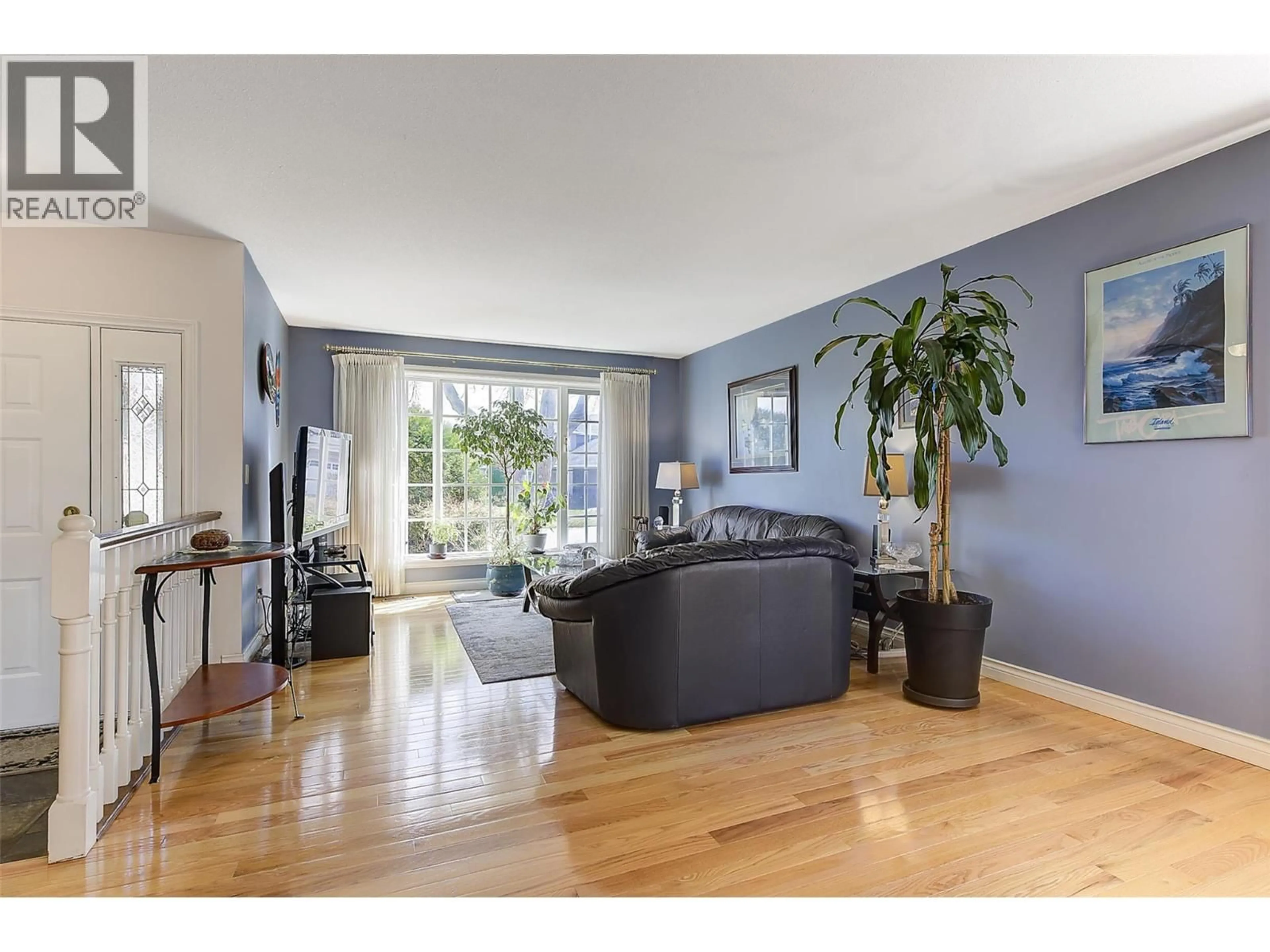 Living room with furniture, wood/laminate floor for 889 MISSION SPRINGS CRESCENT, Kelowna British Columbia V1W3L9