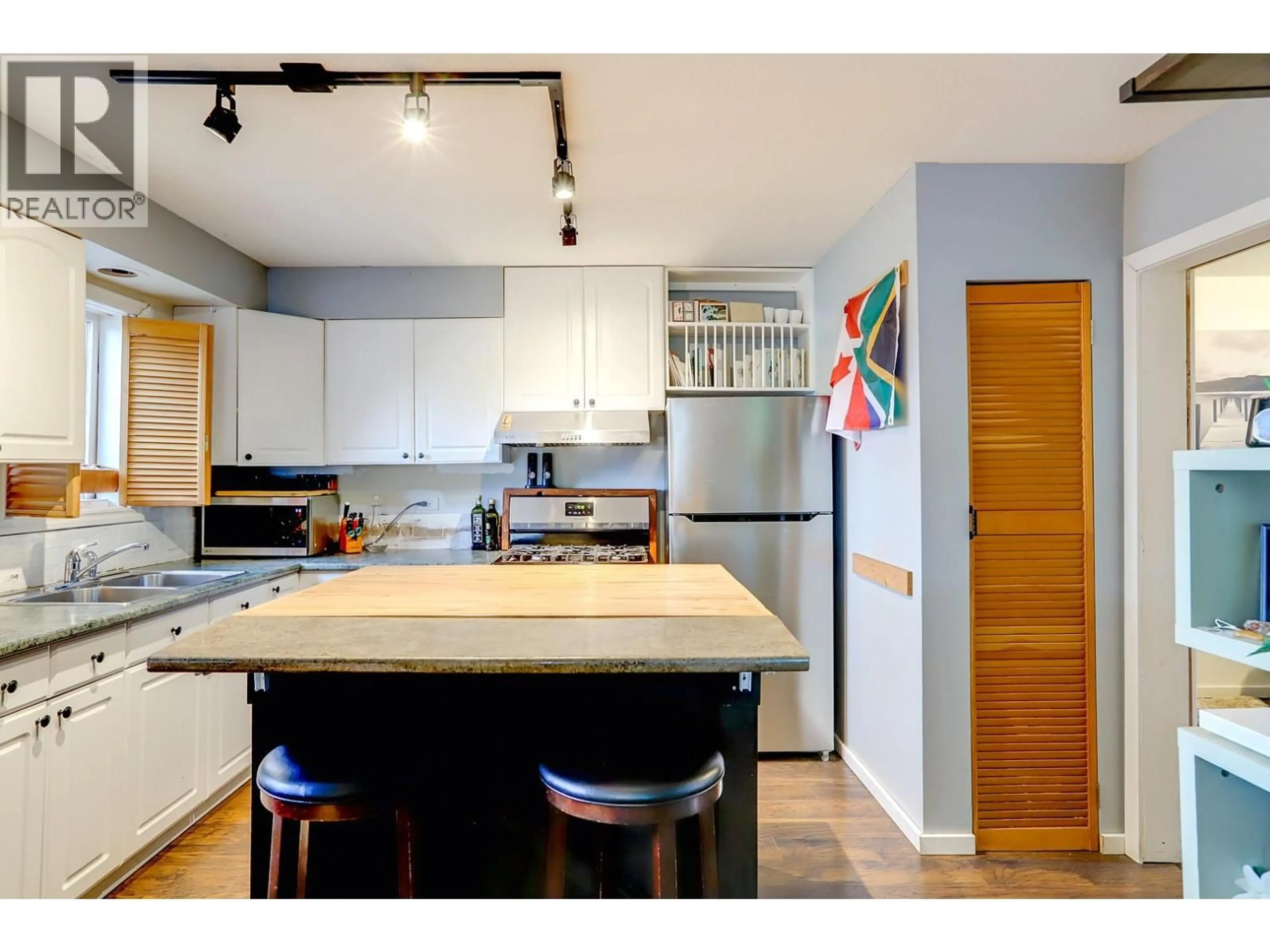 Open concept kitchen, wood/laminate floor for 1703 33 STREET, Vernon British Columbia V1T5P9