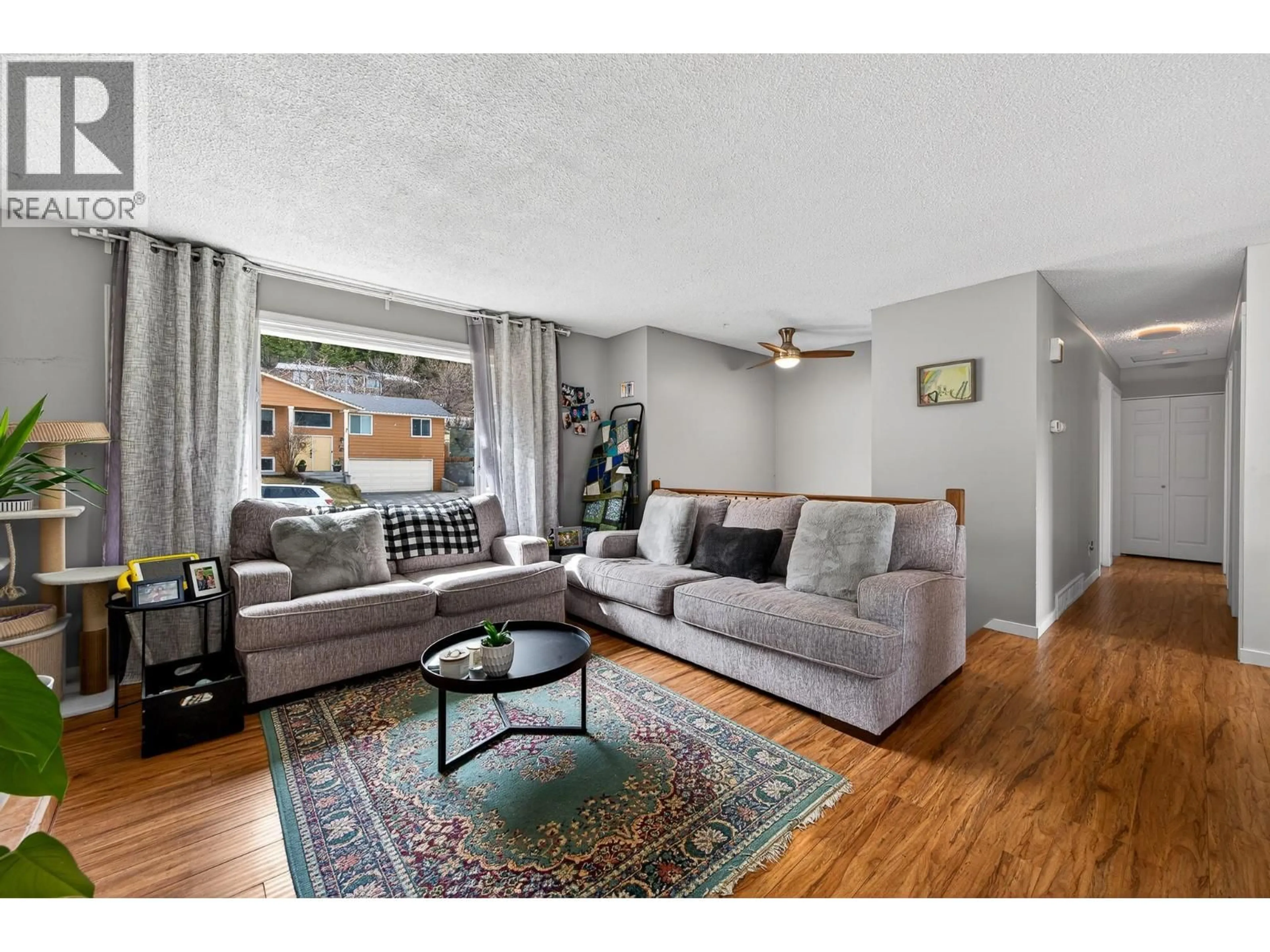 Living room with furniture, wood/laminate floor for 2368 OMINECA DRIVE, Kamloops British Columbia V2E1X3