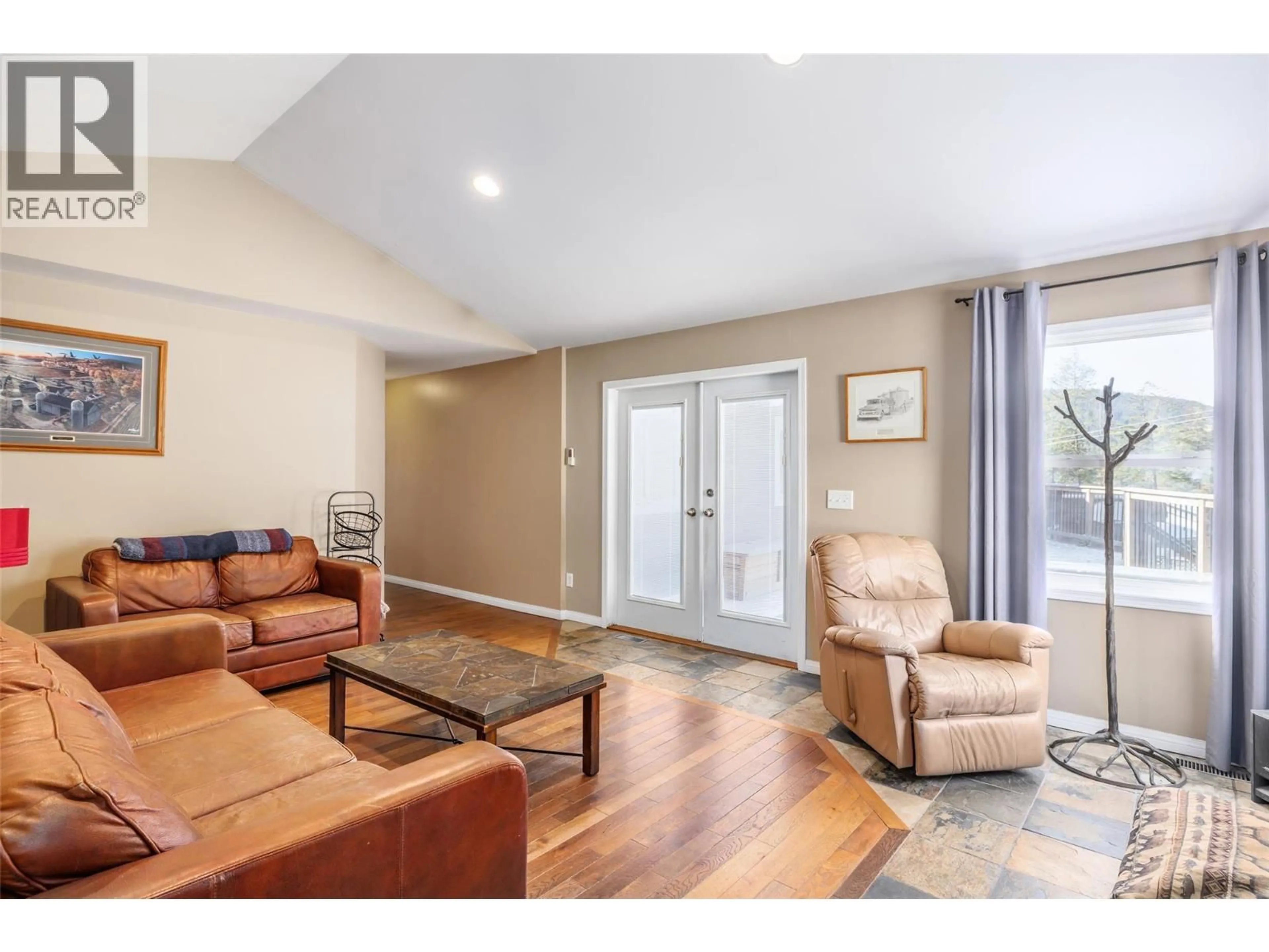 Living room with furniture, wood/laminate floor for 7992 FALCON RIDGE CRESCENT, Kelowna British Columbia V1P1J2