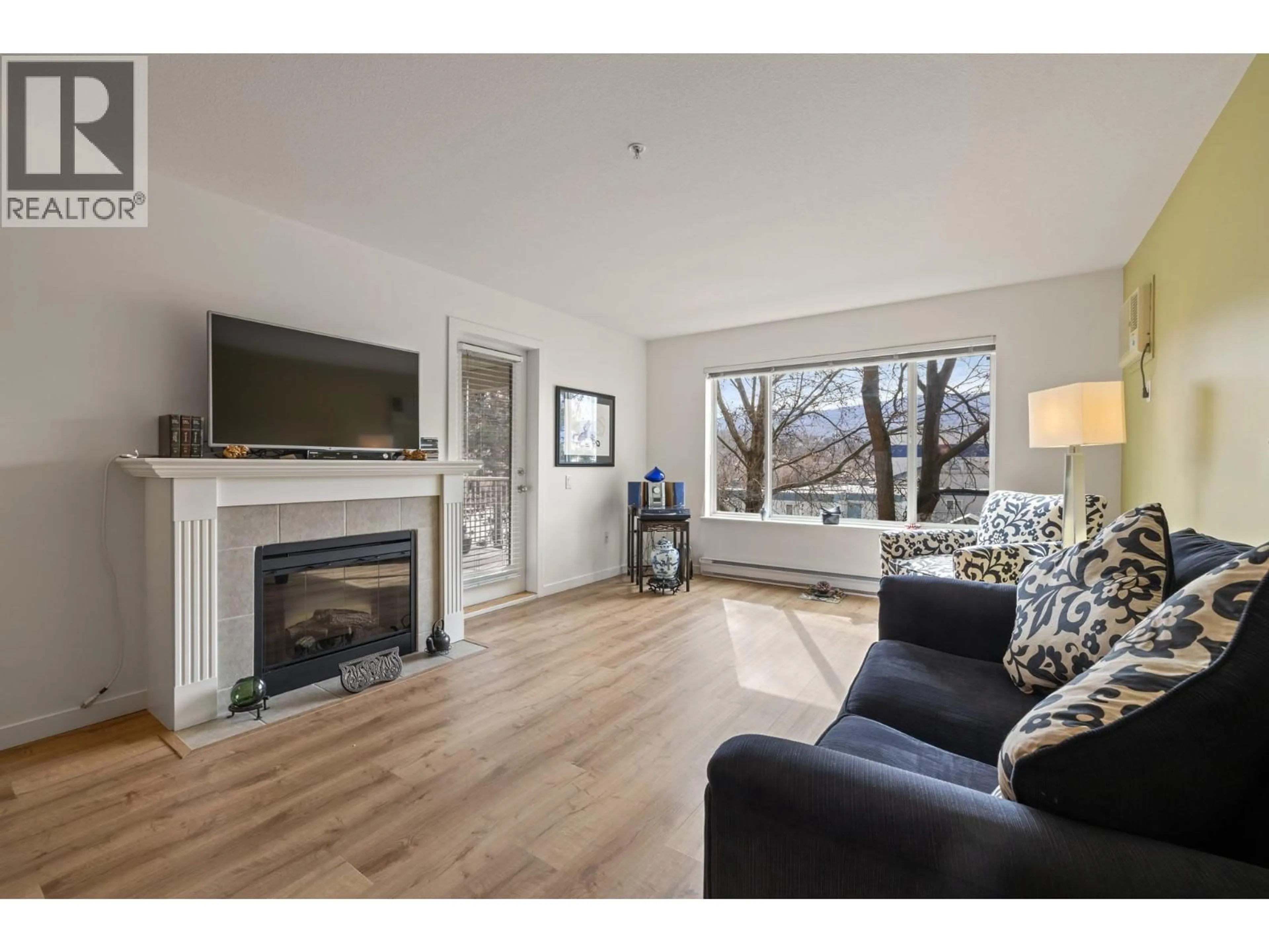 Living room with furniture, wood/laminate floor for 204 - 686 LEQUIME ROAD, Kelowna British Columbia V1W1A4