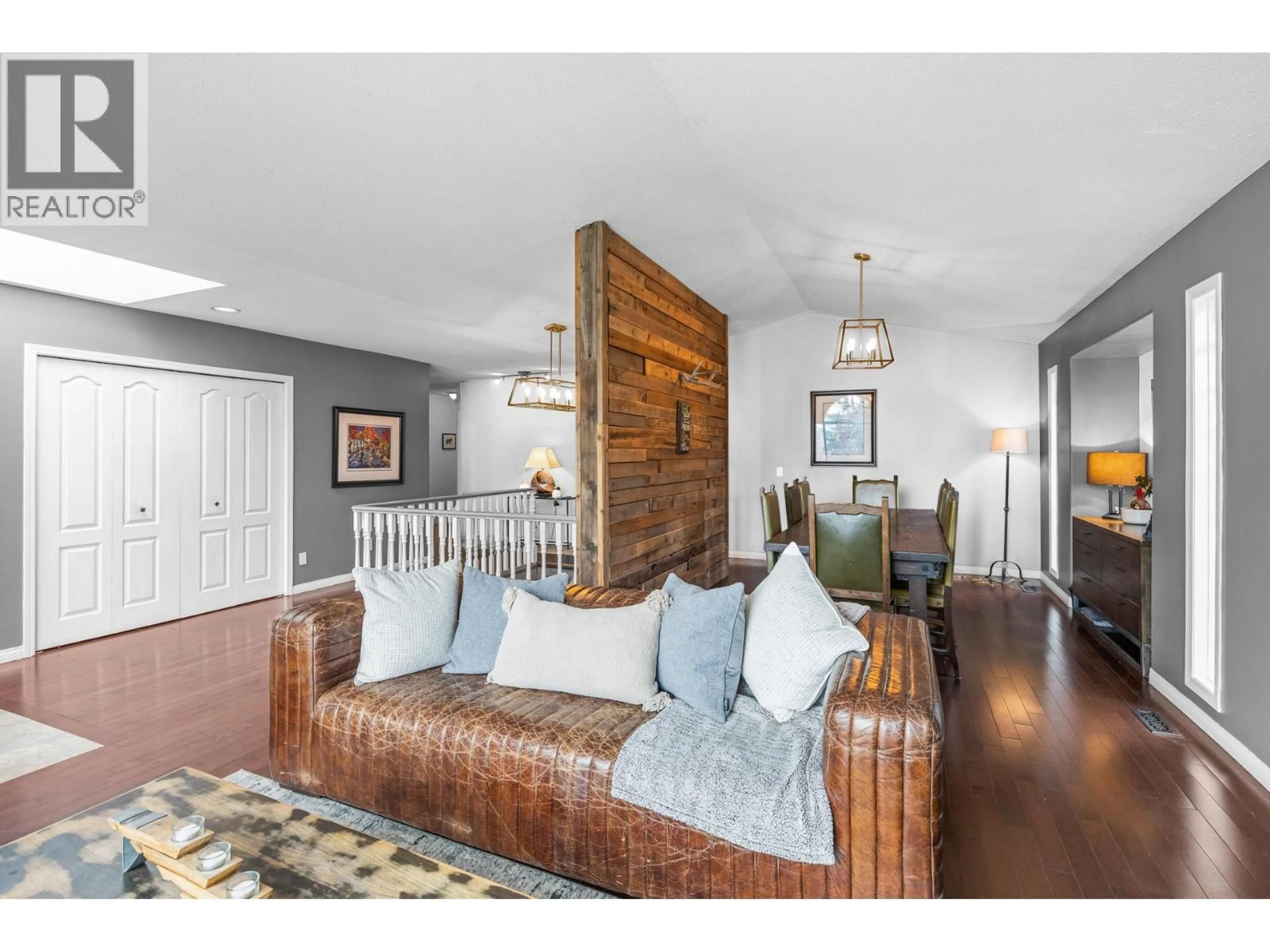 Living room with furniture, wood/laminate floor for 145 MAGIC DRIVE, Kelowna British Columbia V1V1N2