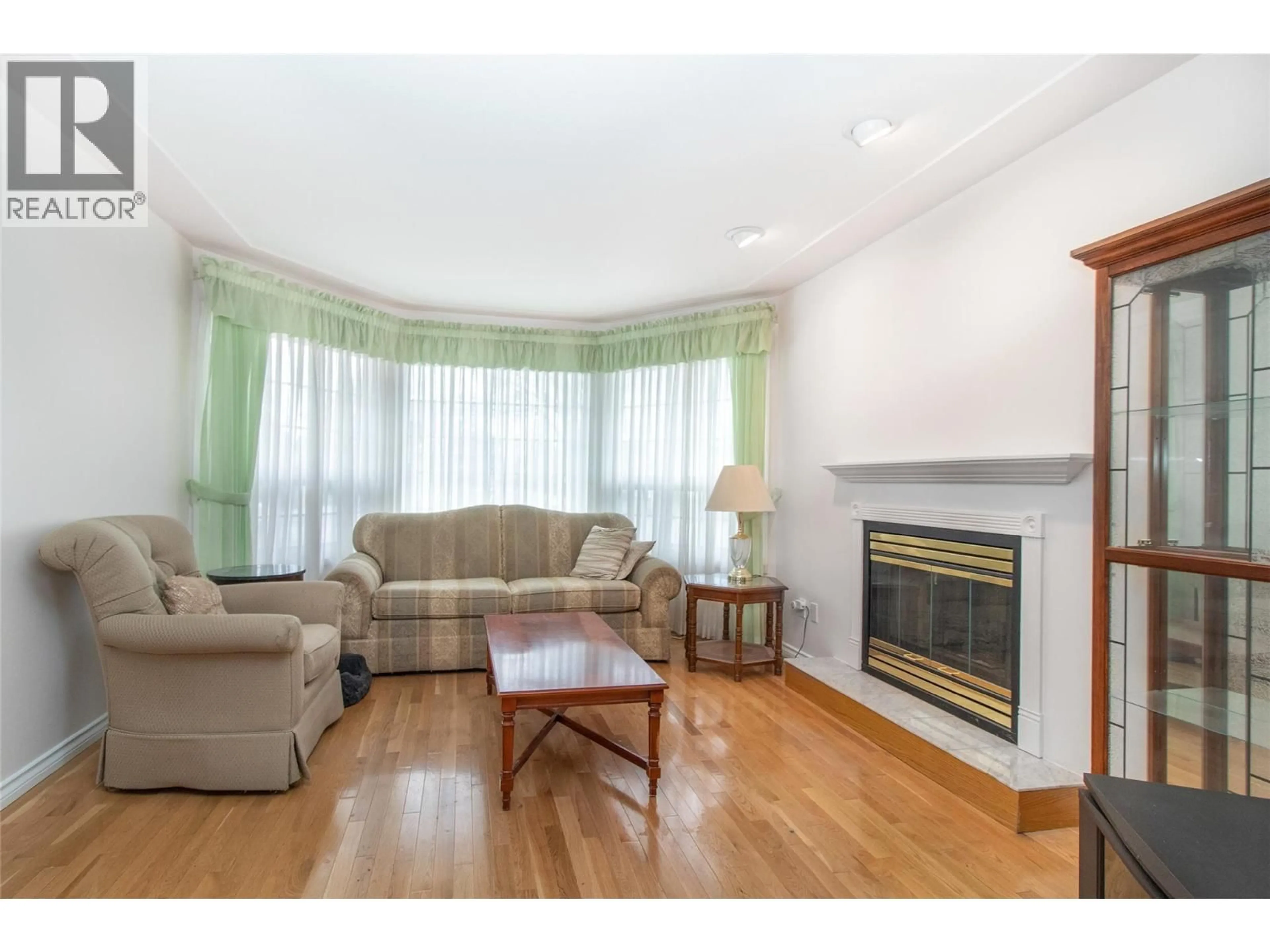 Living room with furniture, wood/laminate floor for 1035 TATARYN ROAD, Kelowna British Columbia V1X1N6