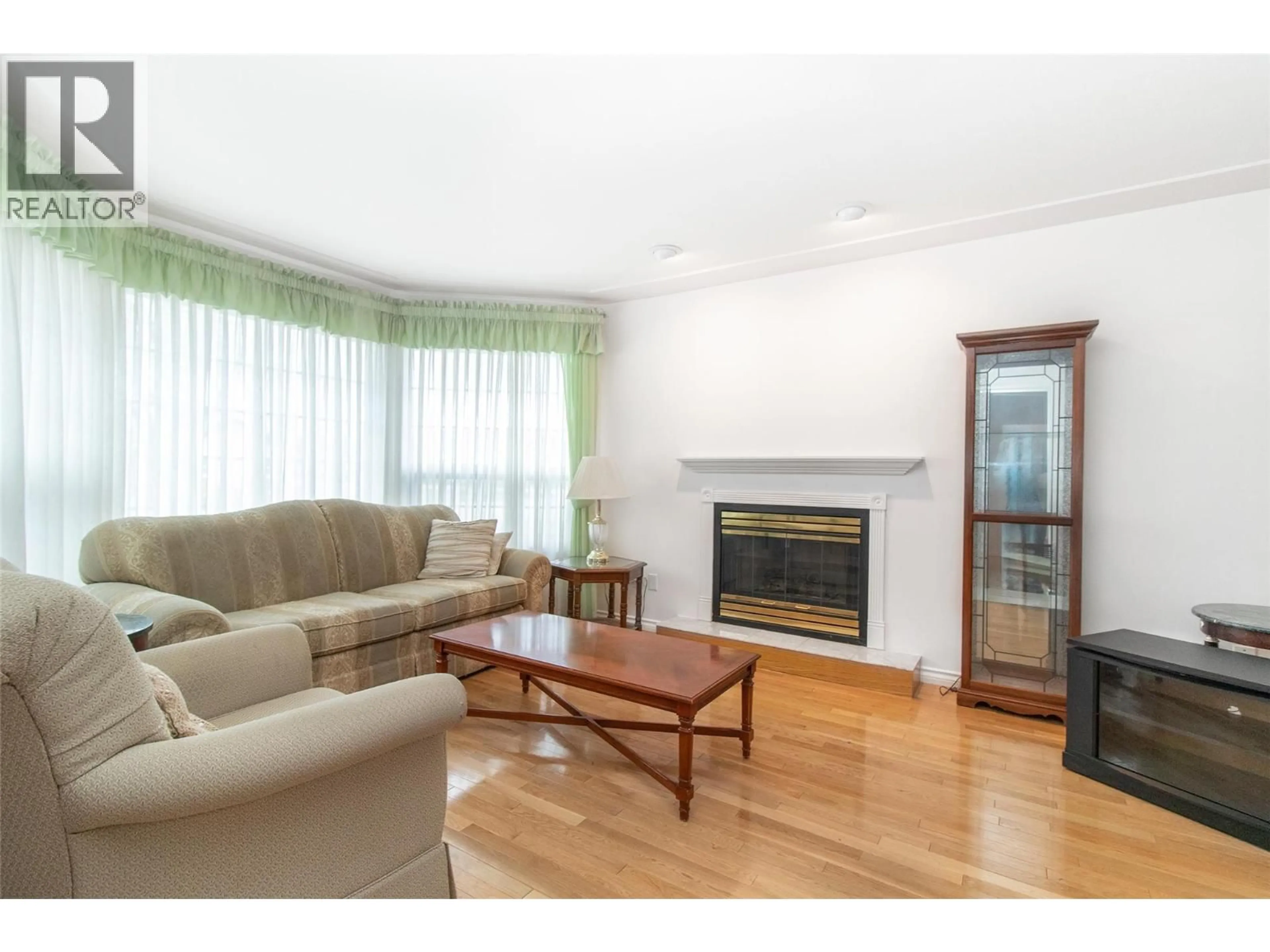Living room with furniture, wood/laminate floor for 1035 TATARYN ROAD, Kelowna British Columbia V1X1N6