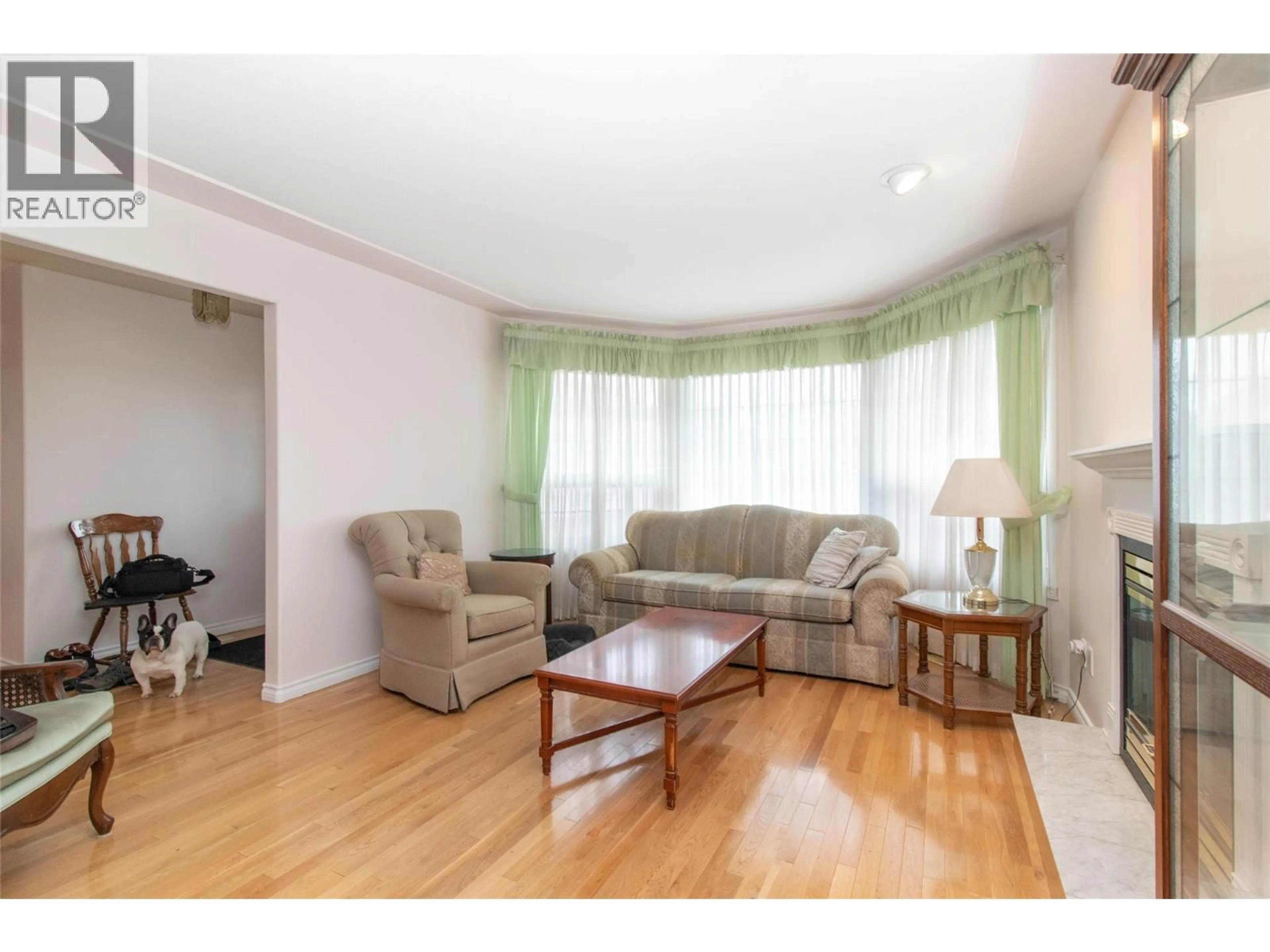 Living room with furniture, wood/laminate floor for 1035 TATARYN ROAD, Kelowna British Columbia V1X1N6