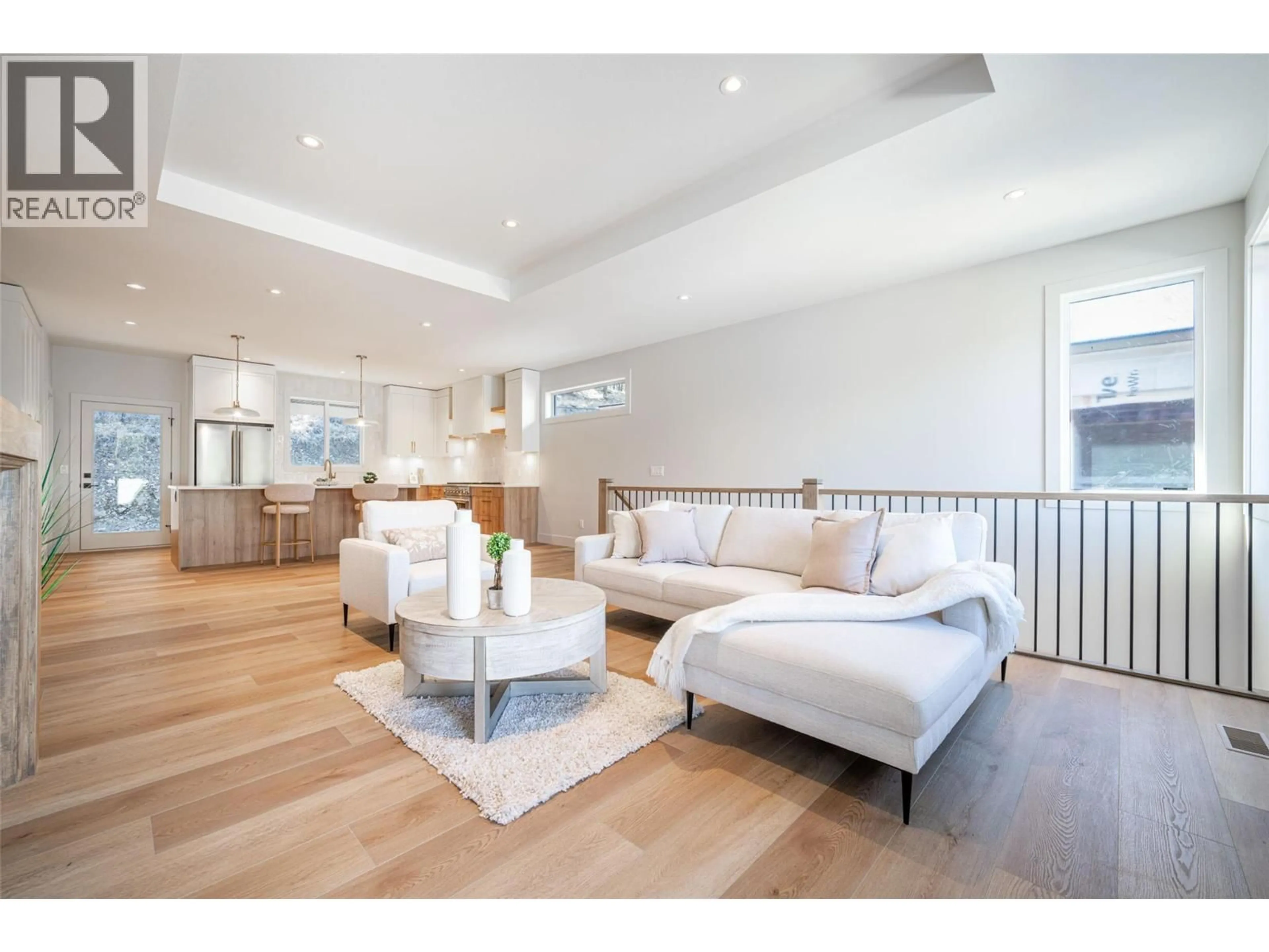 Living room with furniture, wood/laminate floor for 2079 CORTINA DRIVE, Kelowna British Columbia V1P0B2