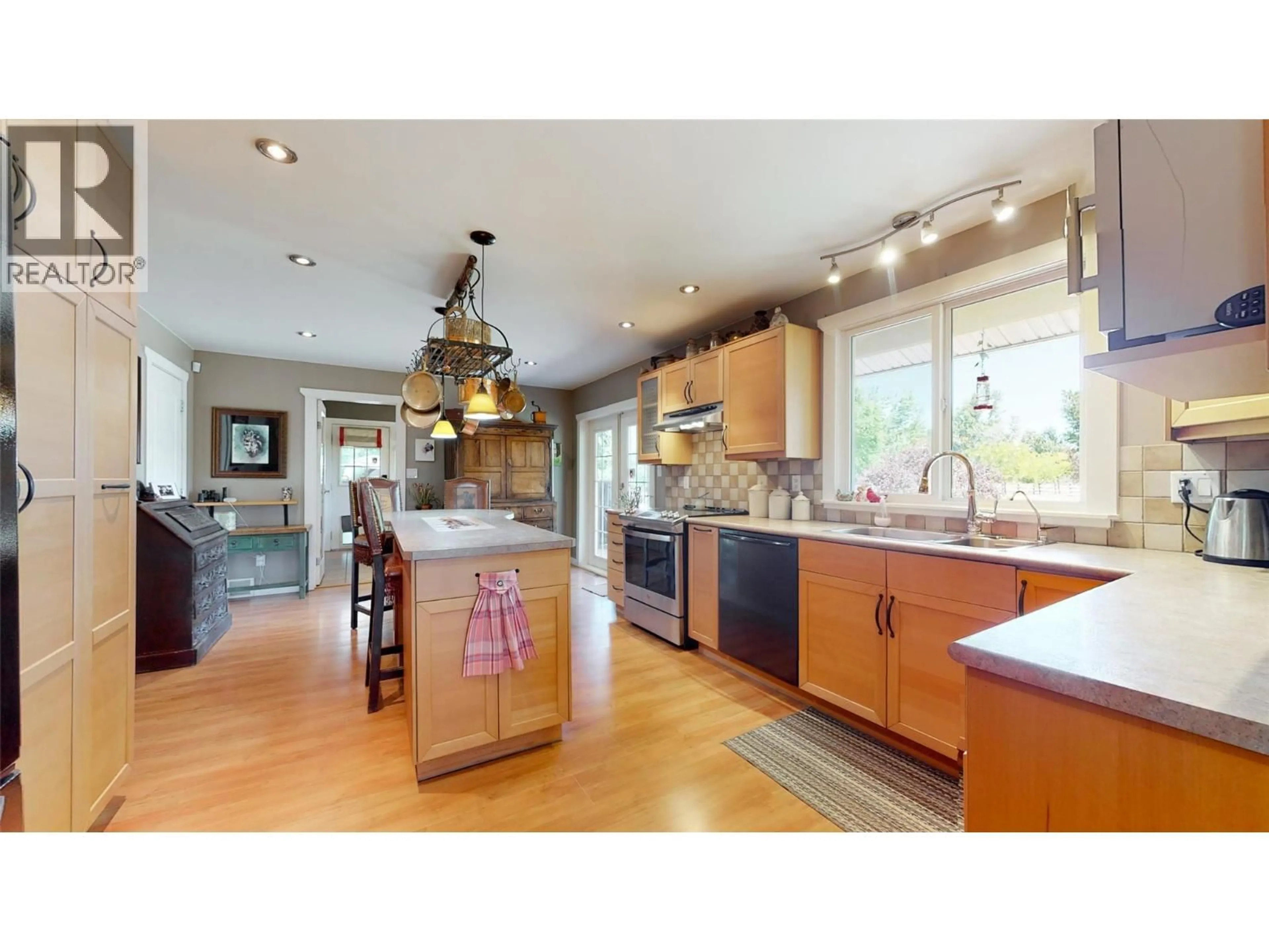 Open concept kitchen, wood/laminate floor for 205 GREASEWOOD AVENUE, Oliver British Columbia V0H1T1