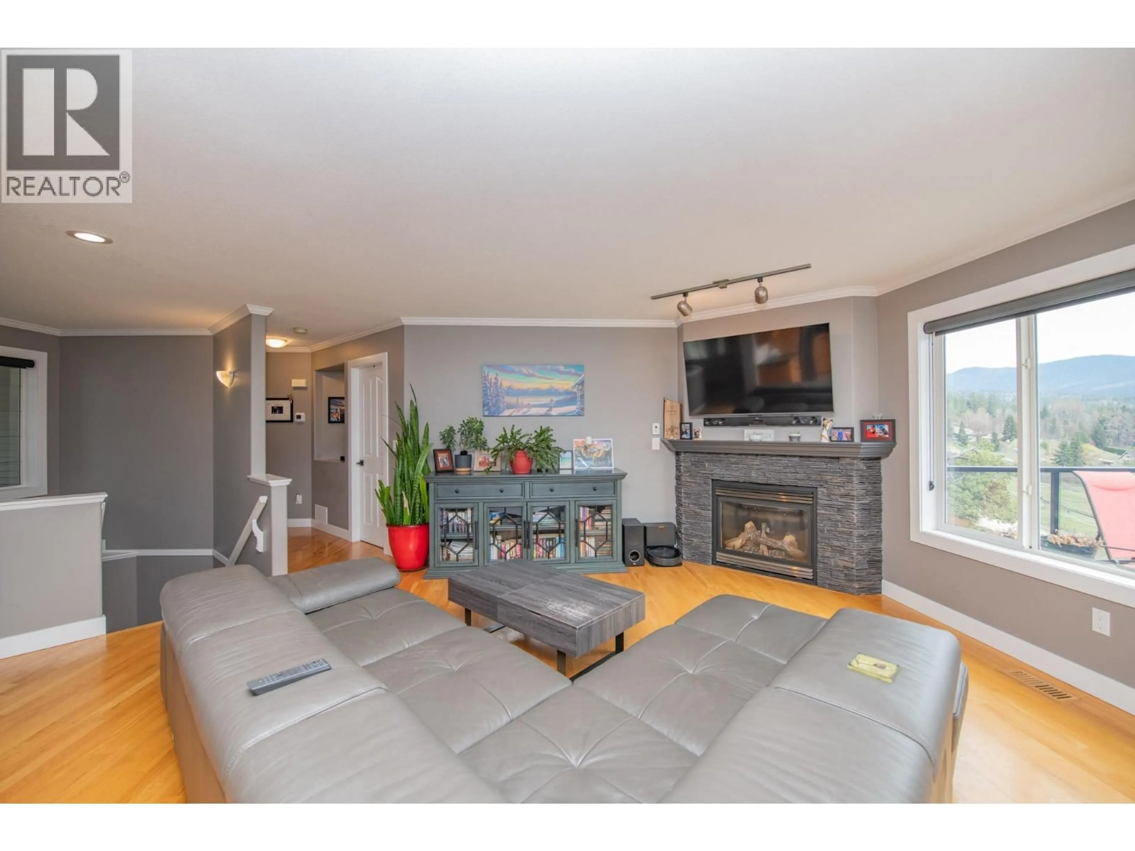 Living room with furniture, wood/laminate floor for 7104 NAKISKA DRIVE, Vernon British Columbia V1B3M5