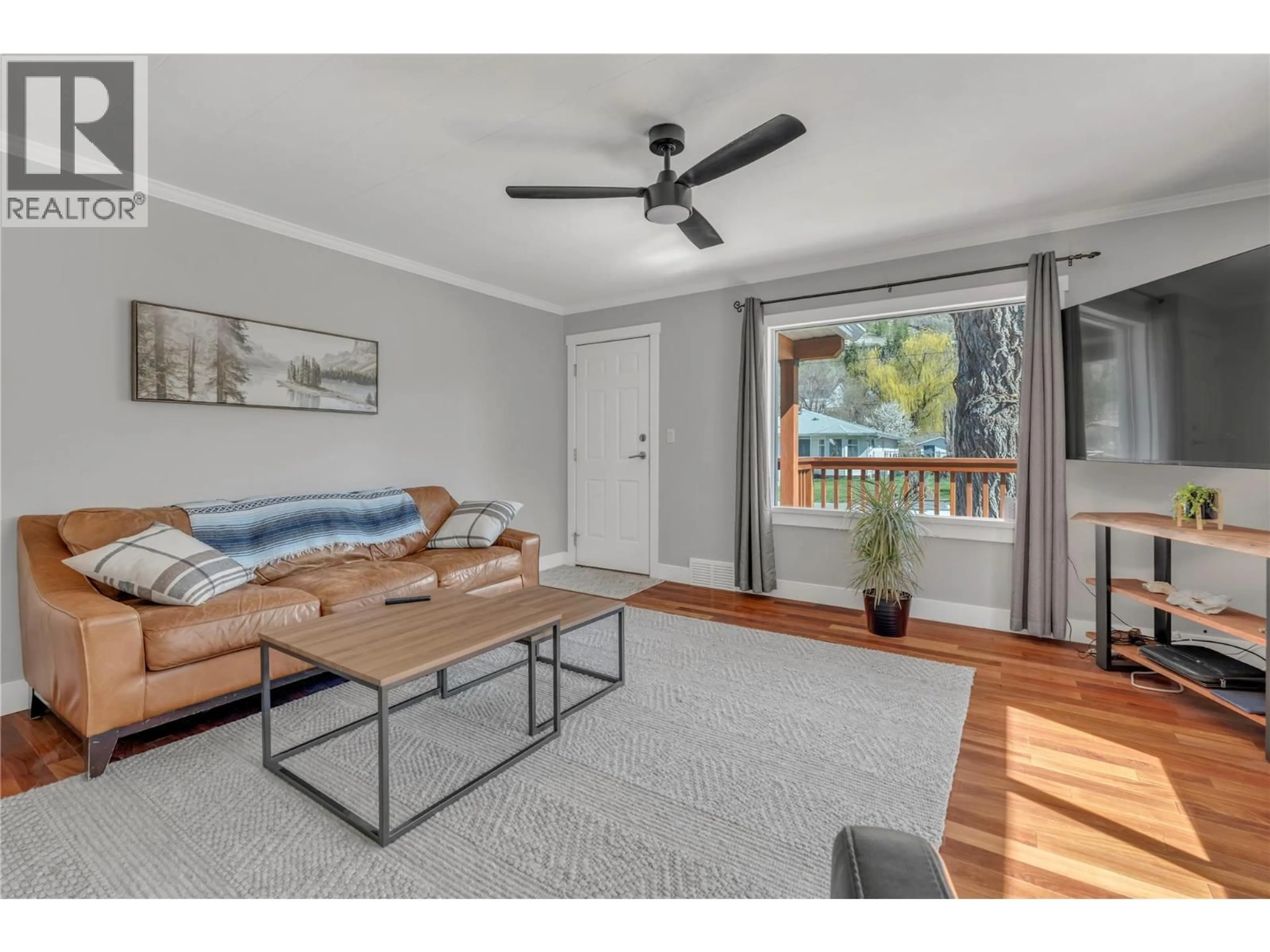 Living room with furniture, wood/laminate floor for 10602 VICTORIA ROAD SOUTH, Summerland British Columbia V0H1Z2