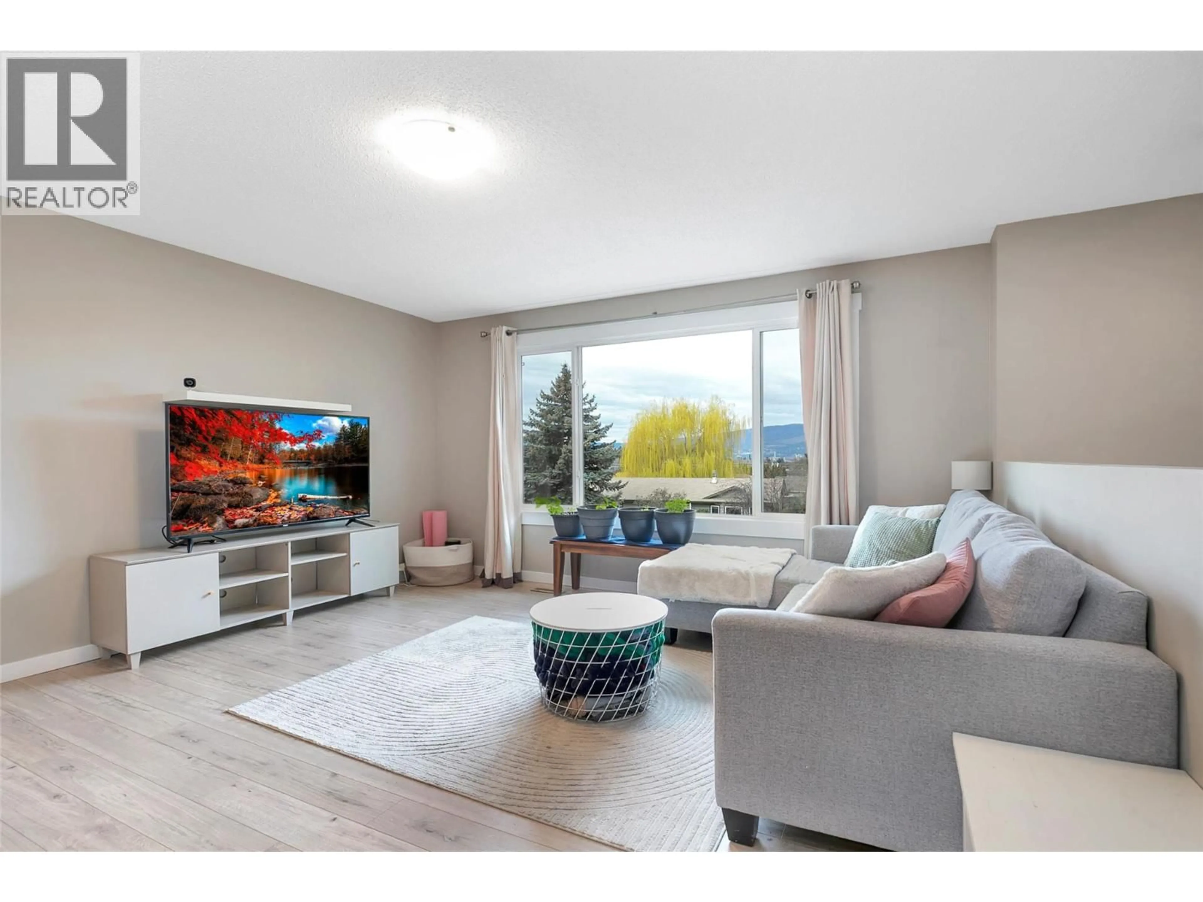 Living room with furniture, wood/laminate floor for 805 CAMELIA ROAD, Kelowna British Columbia V1X3M9