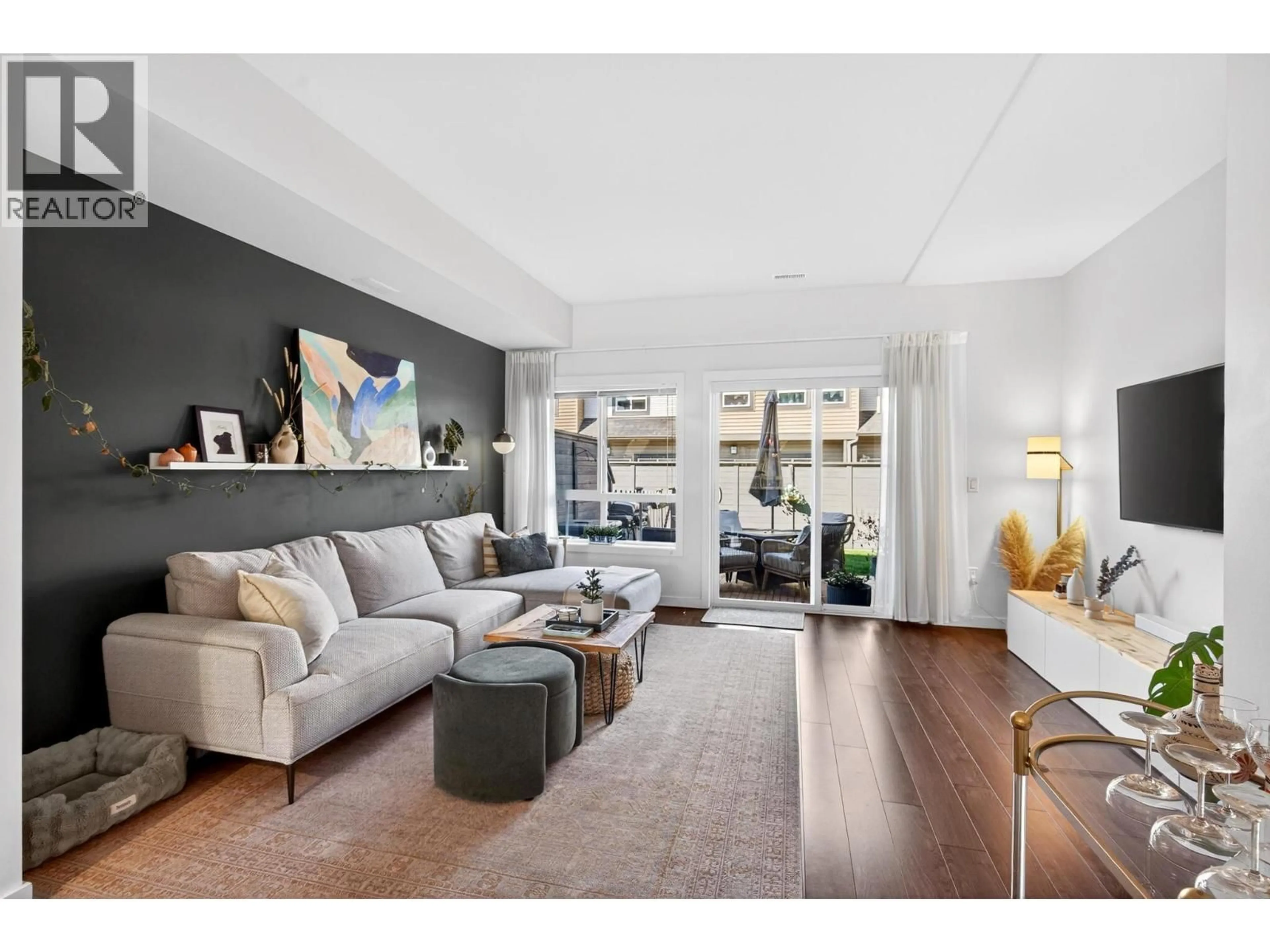 Living room with furniture, wood/laminate floor for 33 - 680 OLD MEADOWS ROAD, Kelowna British Columbia V1W5L4