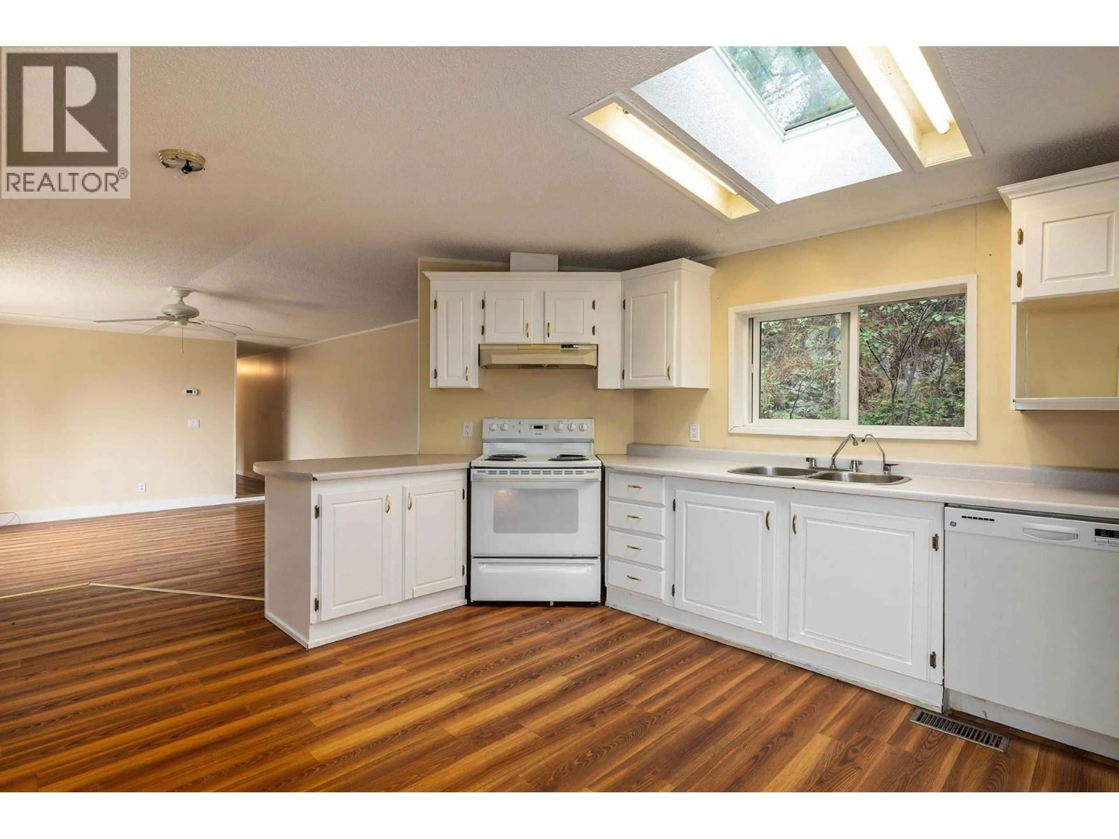 Open concept kitchen, wood/laminate floor for 6439 FARMERS DRIVE, Kelowna British Columbia V1P1A2