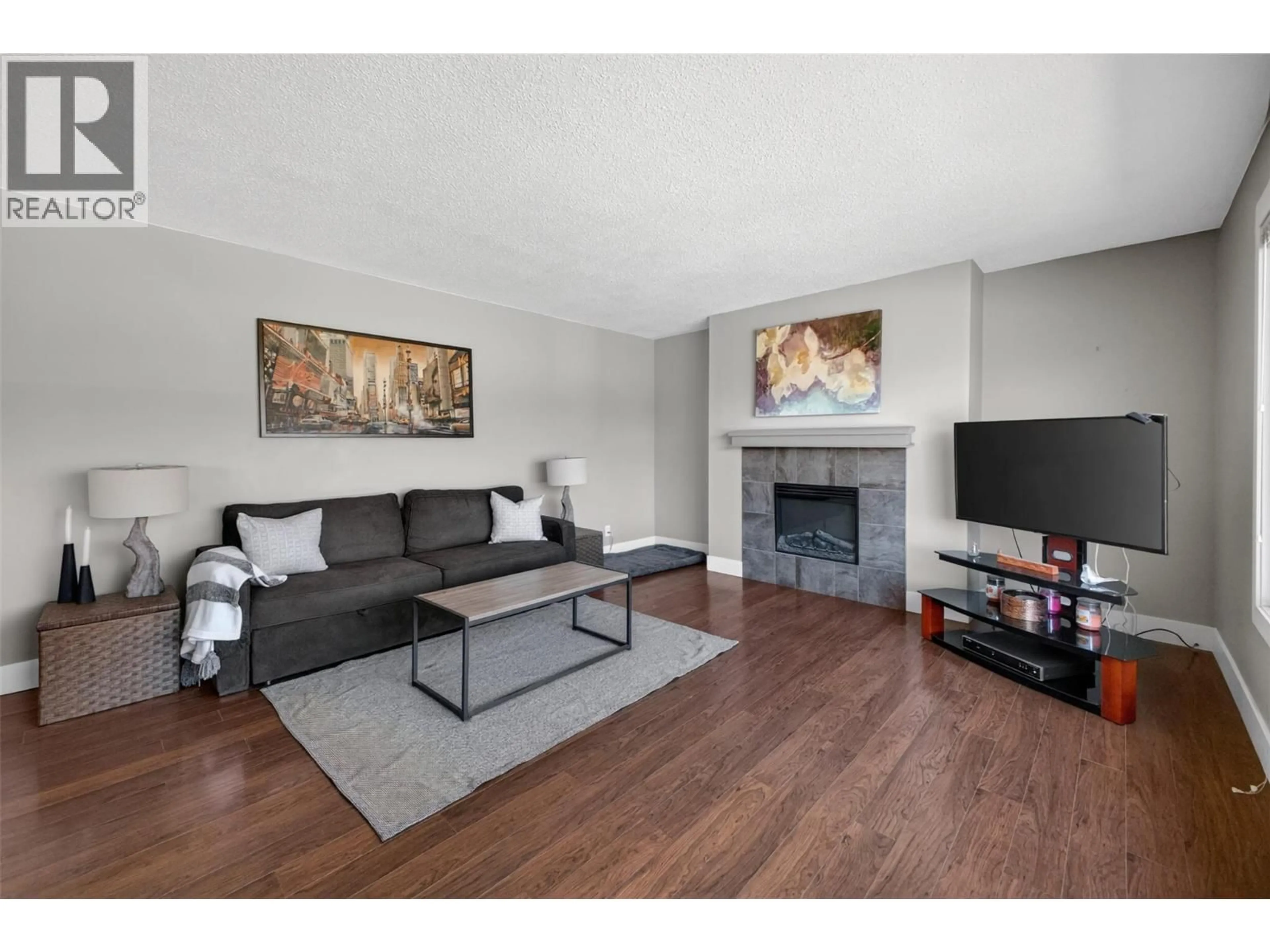 Living room with furniture, wood/laminate floor for 2126 VERDE VISTA ROAD, Kelowna British Columbia V1P1G5