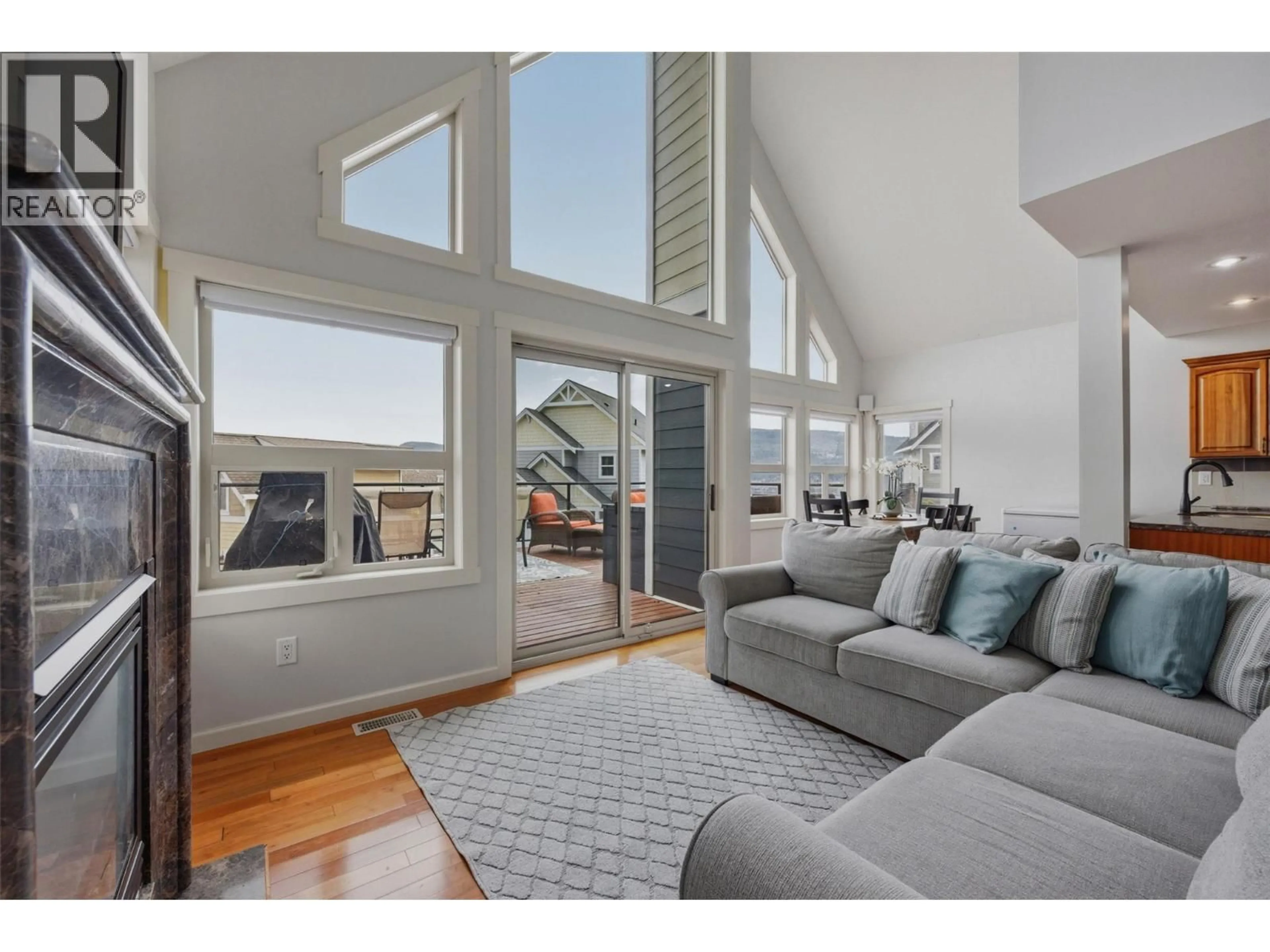 Living room with furniture, wood/laminate floor for 220 - 6765 LA PALMA LOOP, Kelowna British Columbia V1Z3R8