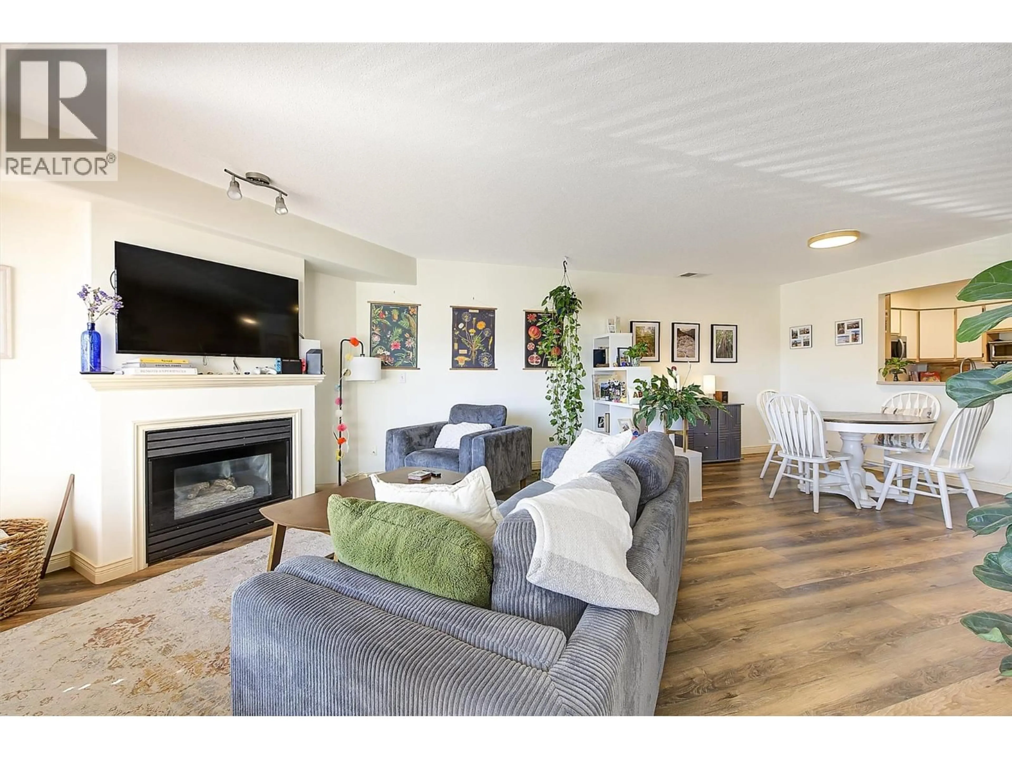 Living room with furniture, wood/laminate floor for 314 - 265 SNOWSELL STREET, Kelowna British Columbia V1V1V6