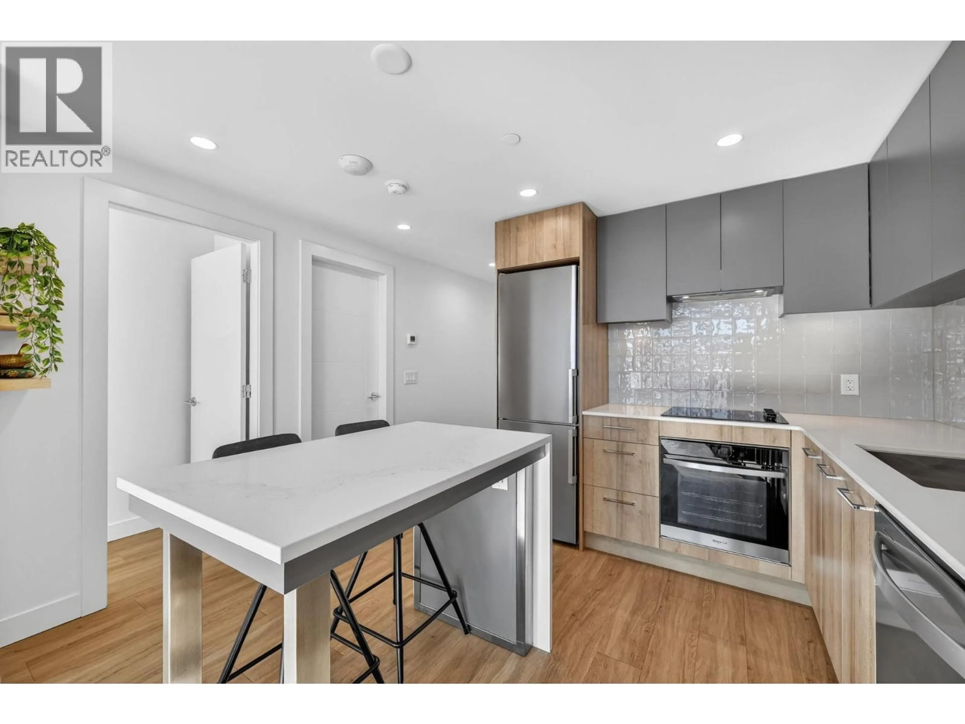 Open concept kitchen, wood/laminate floor for 703 - 3699 CAPOZZI ROAD, Kelowna British Columbia V1W3L2