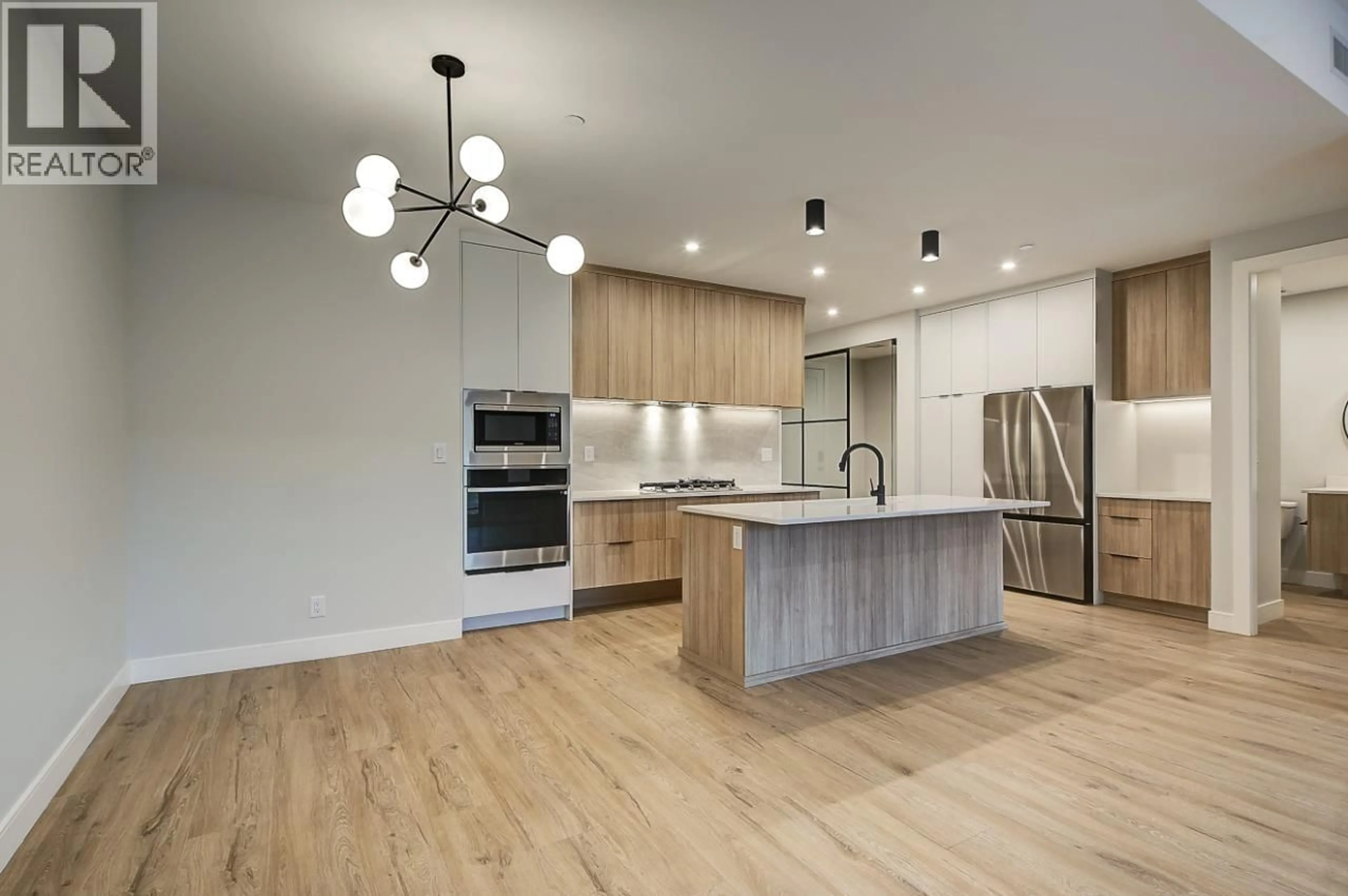 Open concept kitchen, wood/laminate floor for 205 - 75 PREDATOR RIDGE DRIVE, Vernon British Columbia V1H2H1