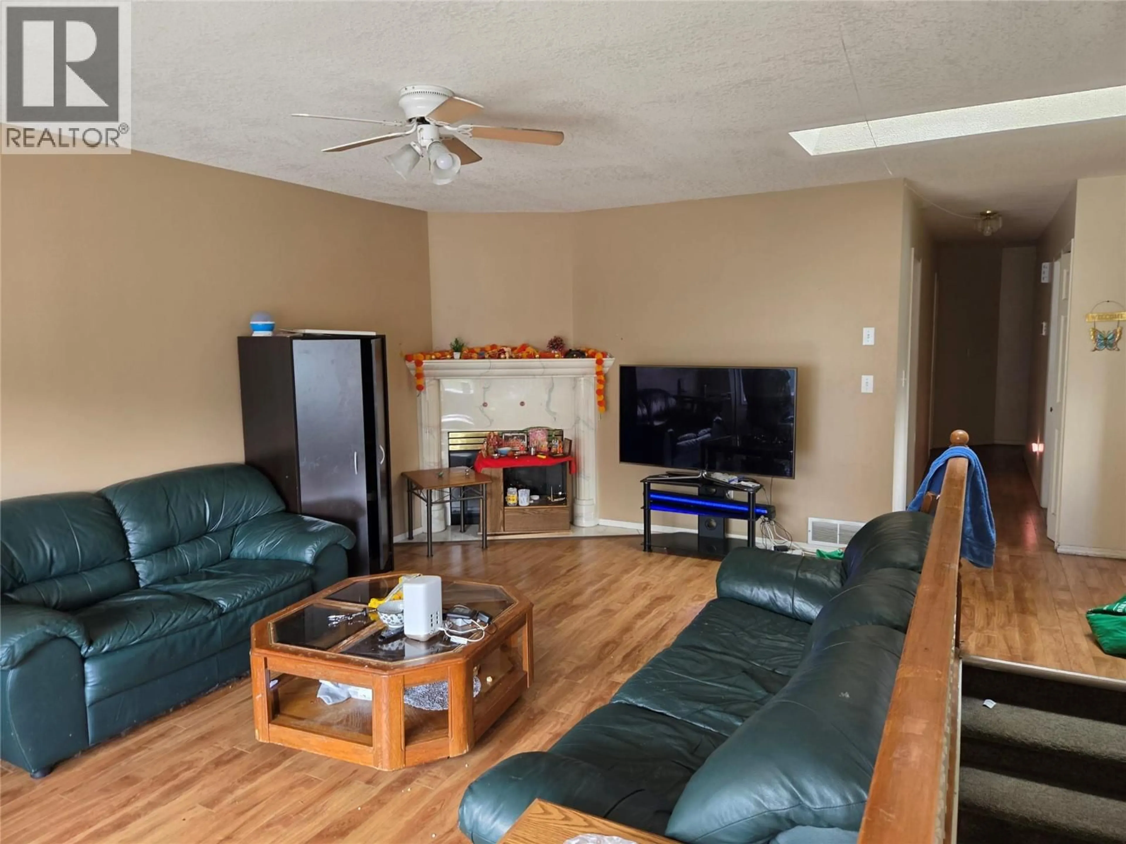 Living room with furniture, wood/laminate floor for 4012 19 STREET, Vernon British Columbia V1T7Y3