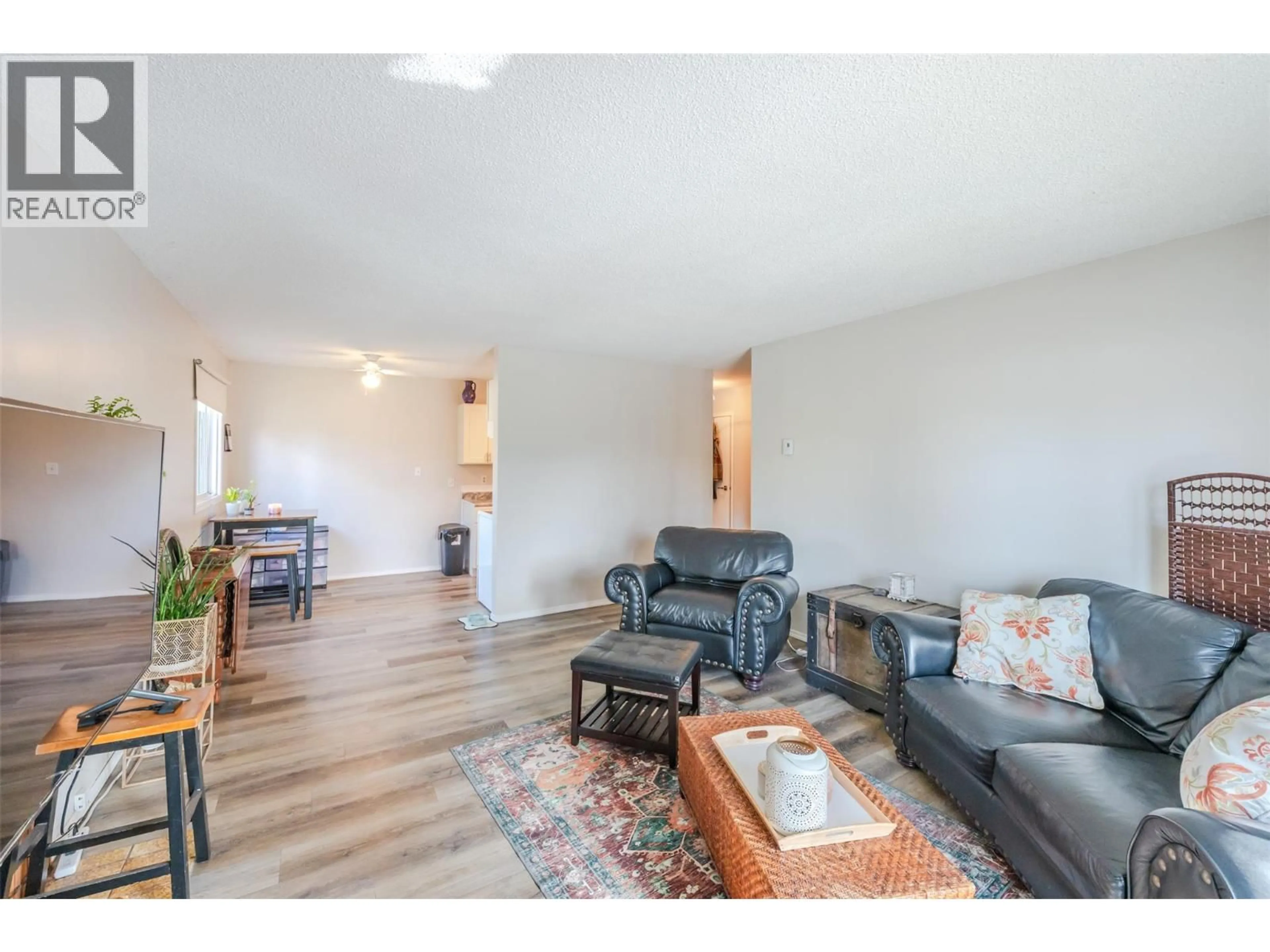 Living room with furniture, wood/laminate floor for 303 - 110 SKAHA PLACE, Penticton British Columbia V2A7L1